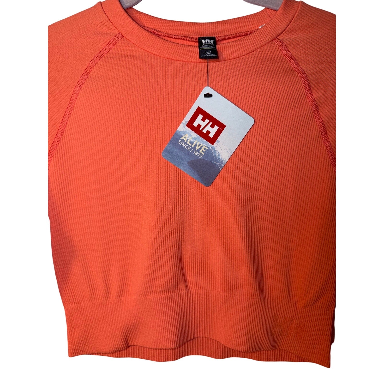 Helly Hansen youth long sleeve T-shirt in peach, size large, with logo on front, casual and comfortable clothing for kids.