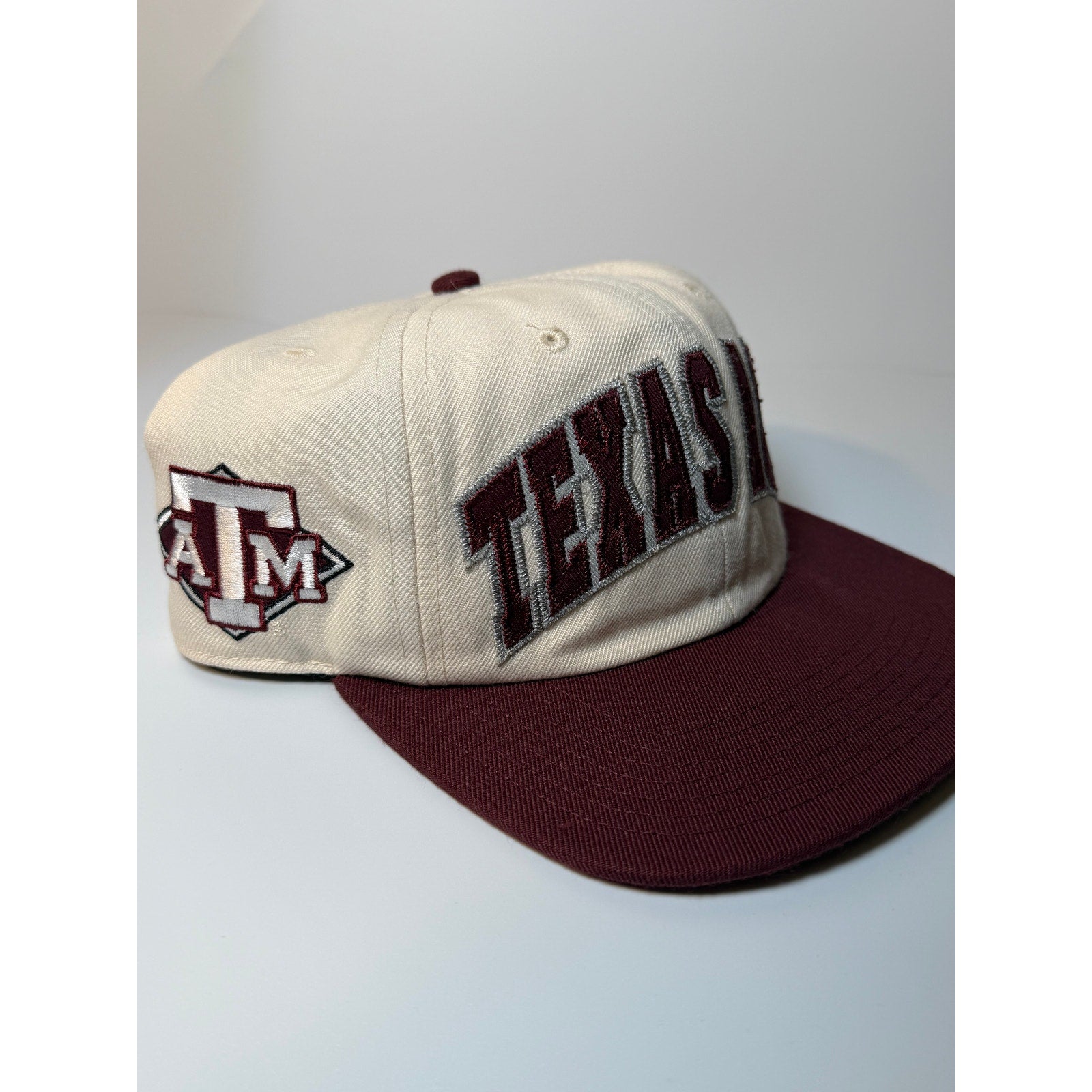 47 Brand Texas A&M Aggies snapback hat in cream and maroon with adjustable strap, featuring team logo and classic baseball cap style.