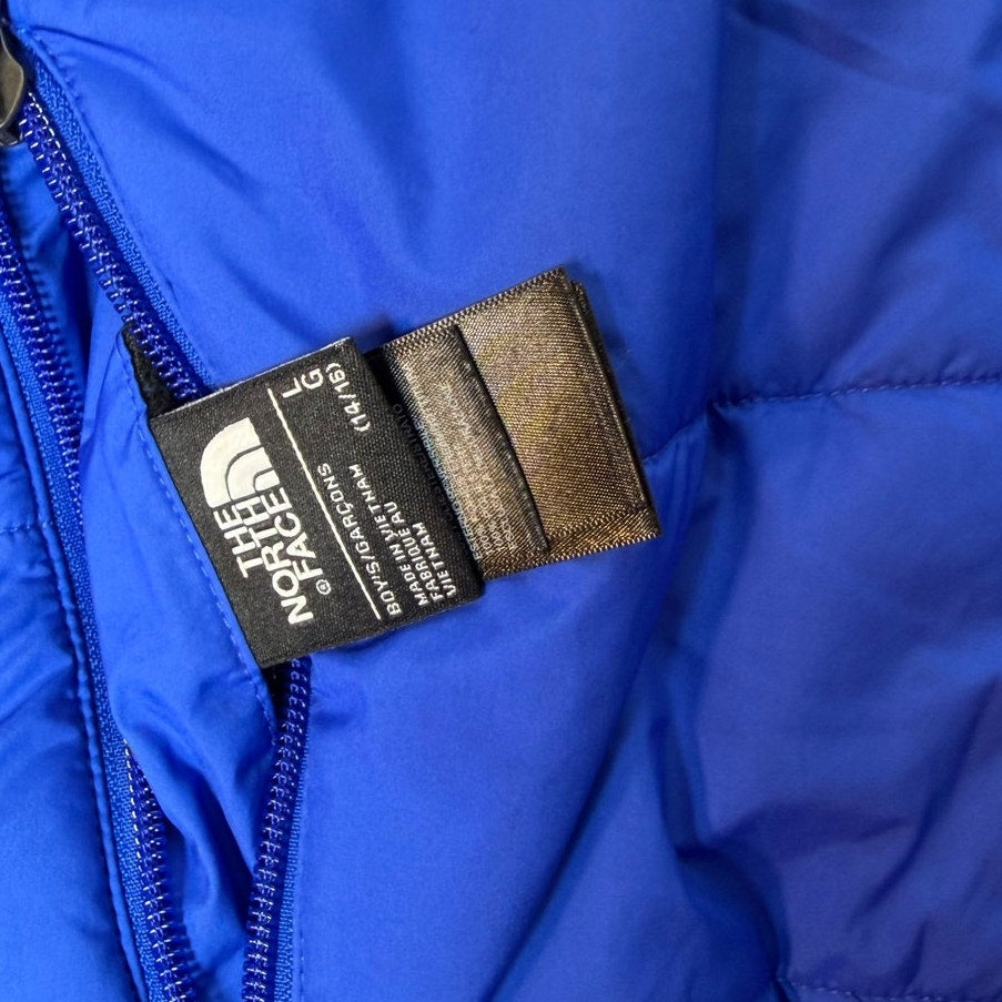 The North Face boys reversible Mount Chimborazo puffer jacket in blue and black, fleece-lined, size large, with quilted and smooth fabric sides.