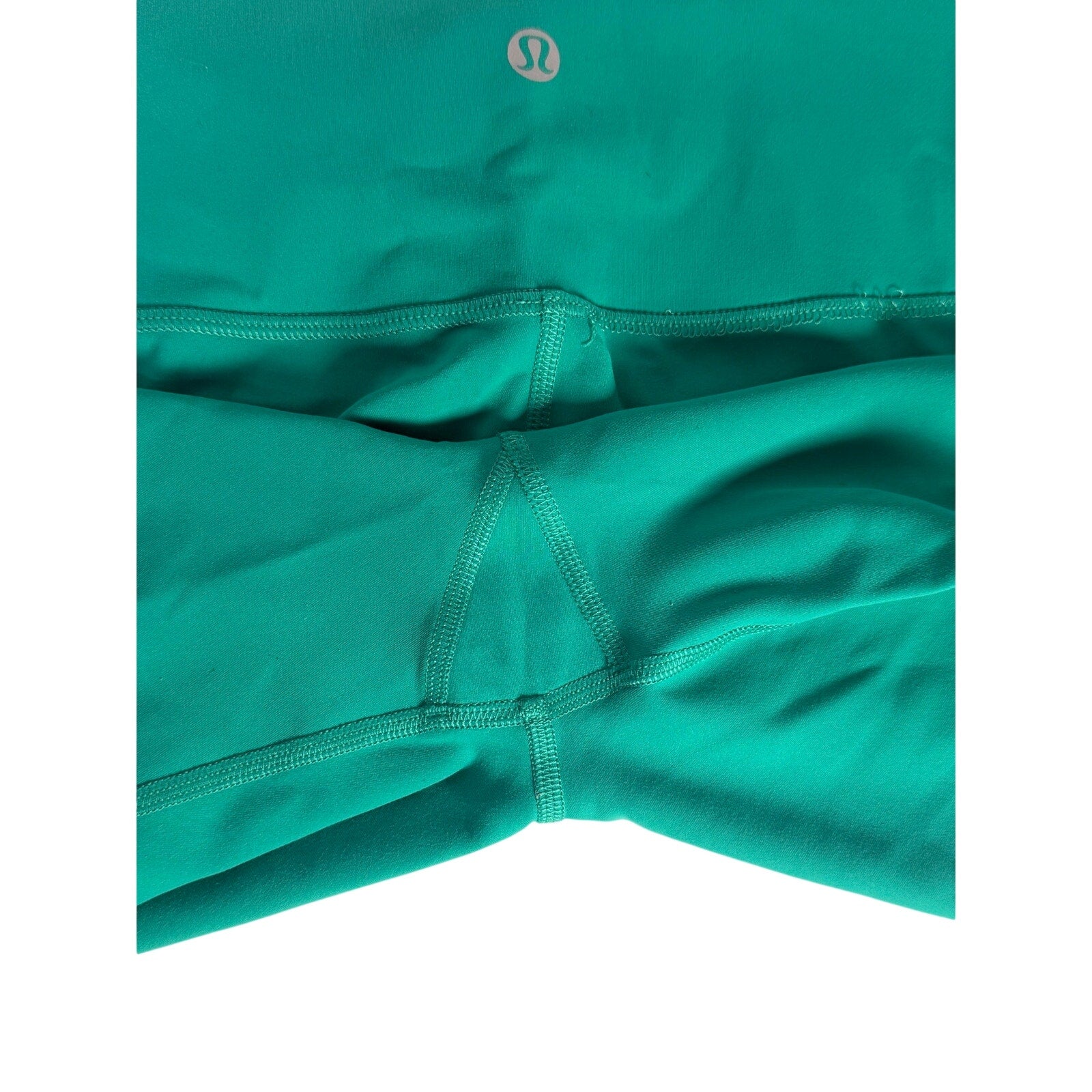 Lululemon women's high-rise teal green biker shorts size 6, made of stretchy athletic fabric, shown on a white background.