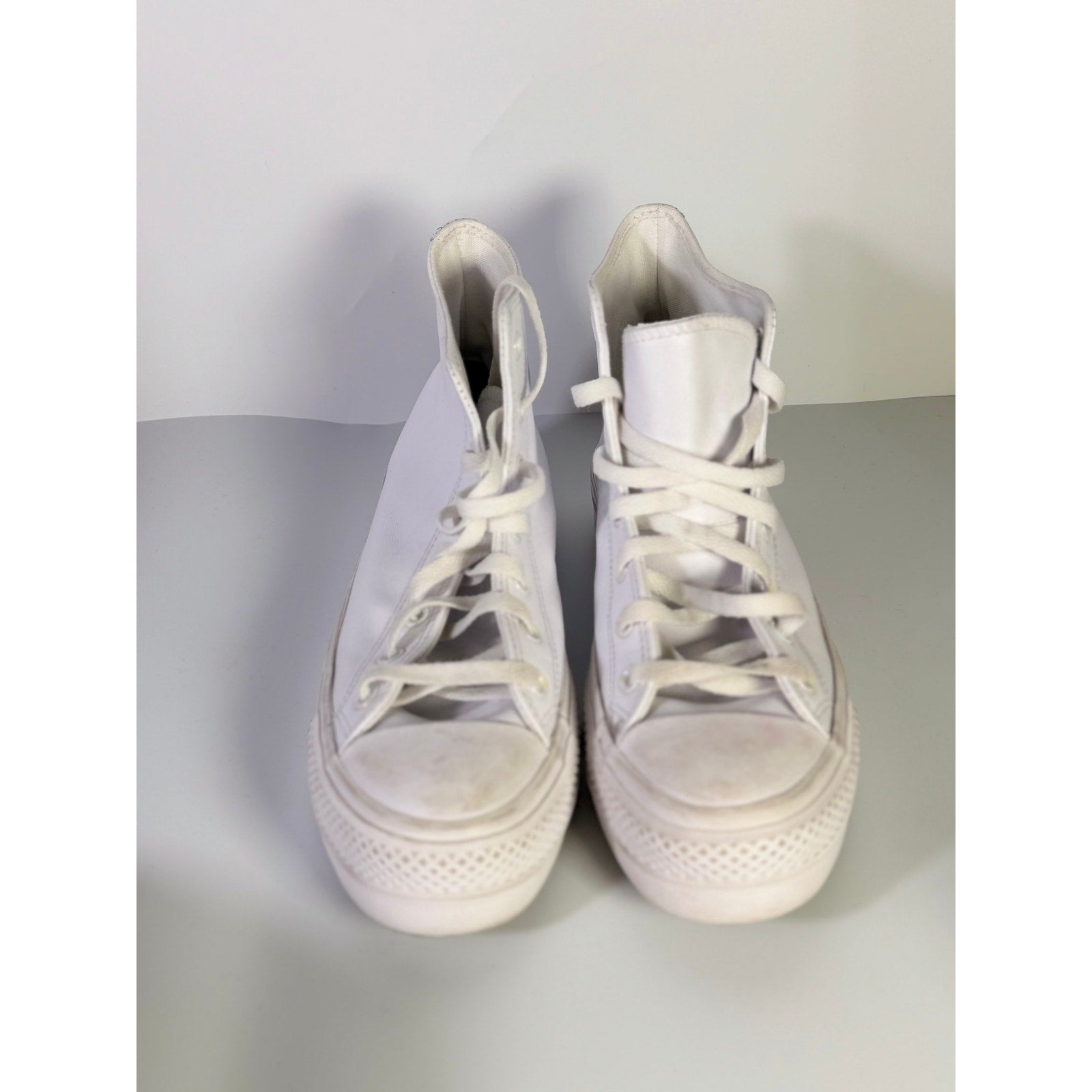 White leather Converse Chuck Taylor All Star Lift Hi sneakers with platform sole, worn by a woman in US size 8.5.