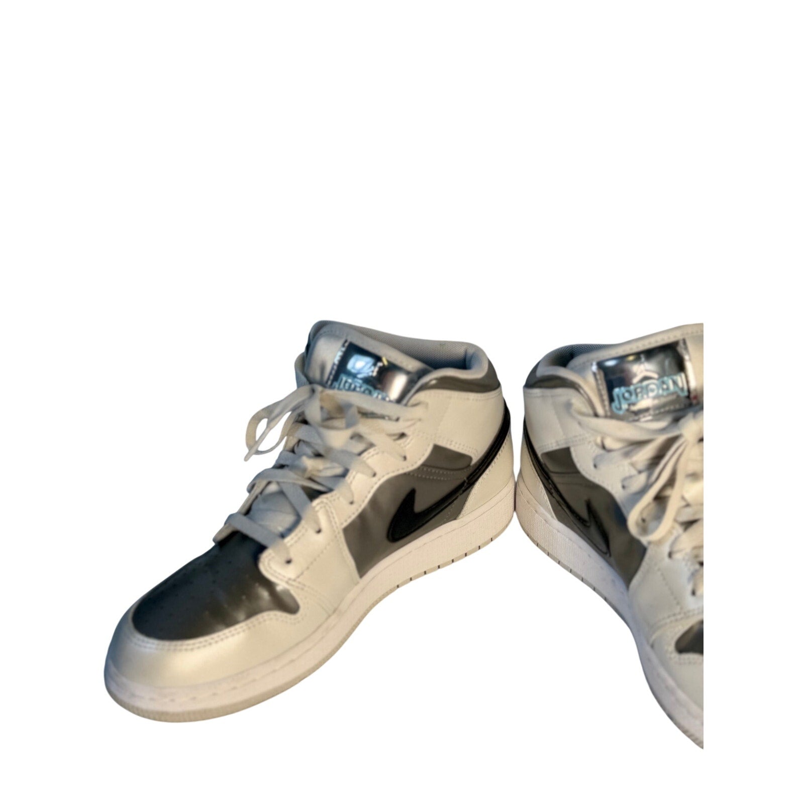 White, gray, and black Air Jordan 1 Mid GS sneakers for youth size 7Y, featuring iconic Jordan branding and classic sneaker design.