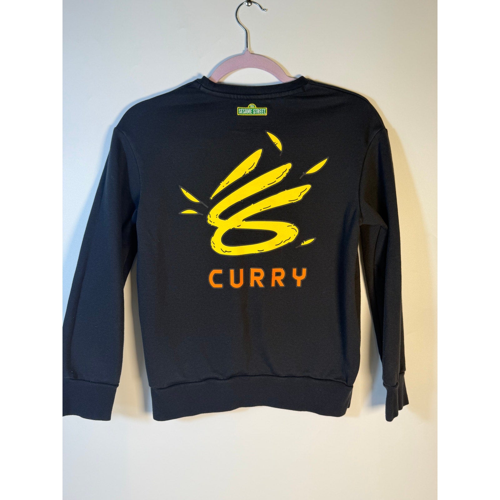 Under Armour Curry Sesame Street Big Bird youth black sweatshirt with Big Bird graphic, suitable for boys, size M.