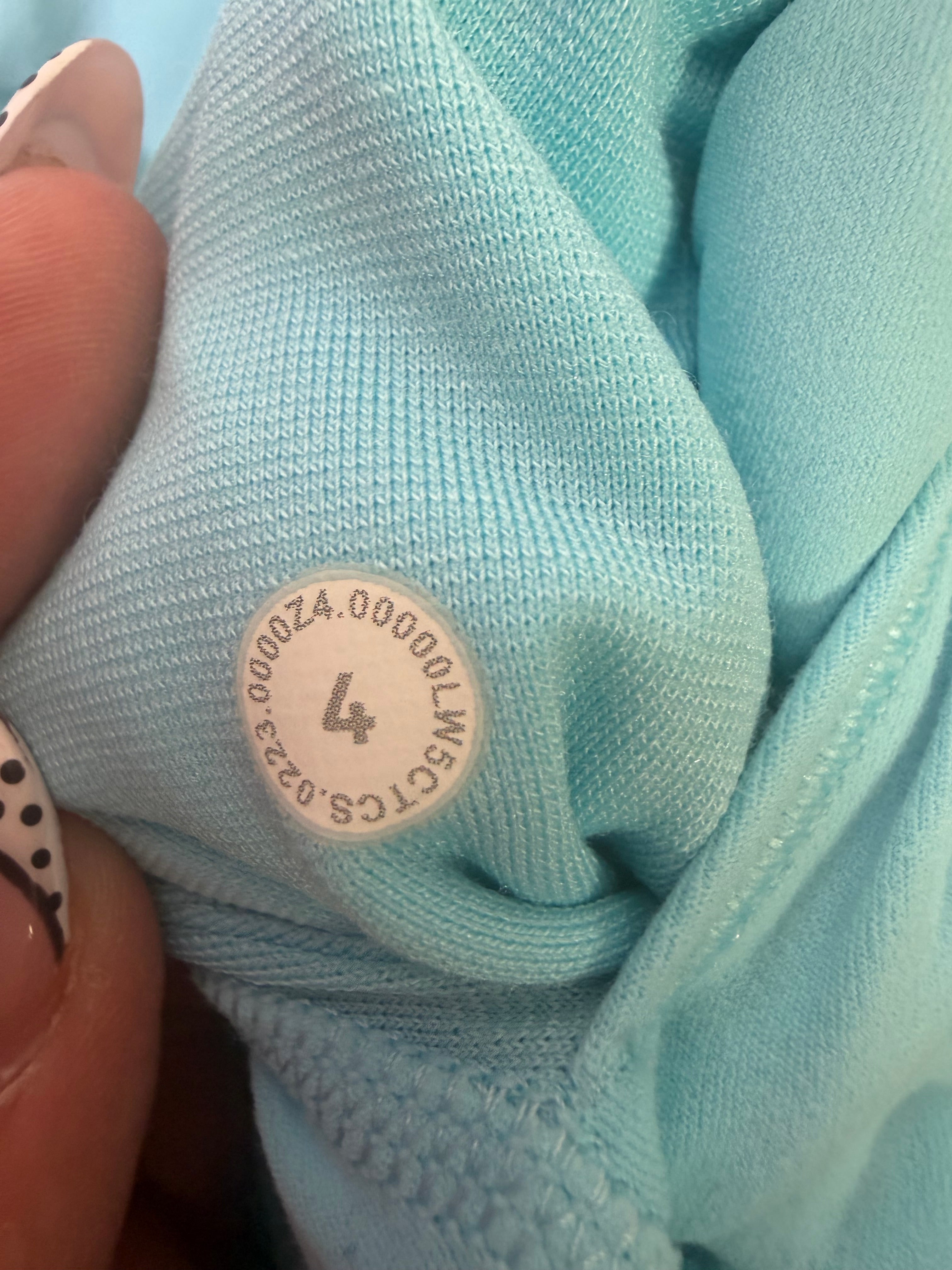 Lululemon women's size 4 aqua blue high-rise full-length leggings laid flat, showcasing the stretchy athletic clothing material.