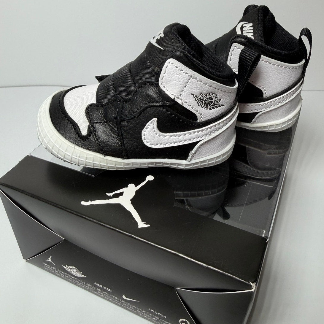 Nike Air Jordan 1 Retro High OG infant sneakers in black and white, designed for babies, featuring classic Jordan style and branding.