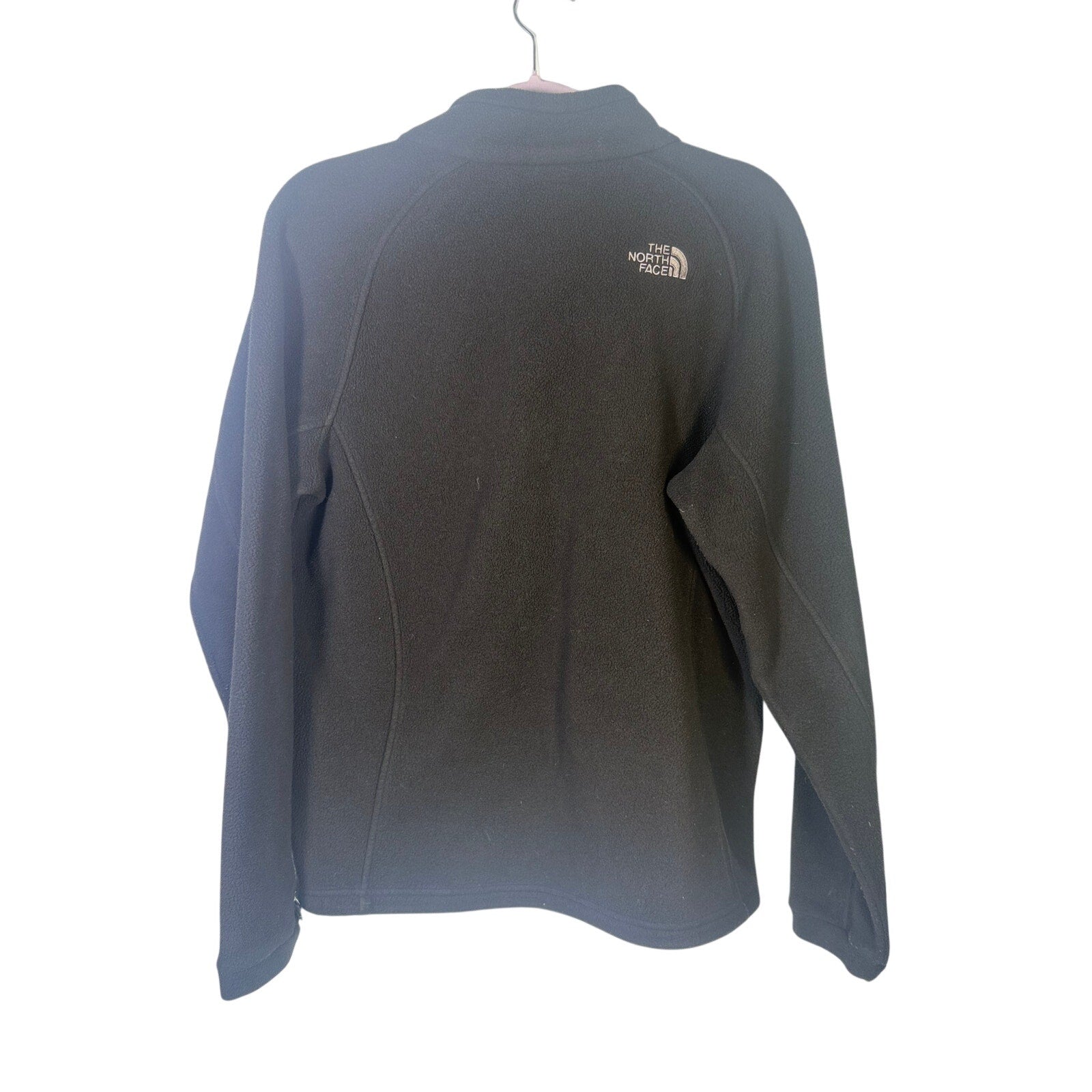 The North Face women's black full-zip fleece jacket with outdoor logo, featuring a cozy fleece texture and adjustable collar.