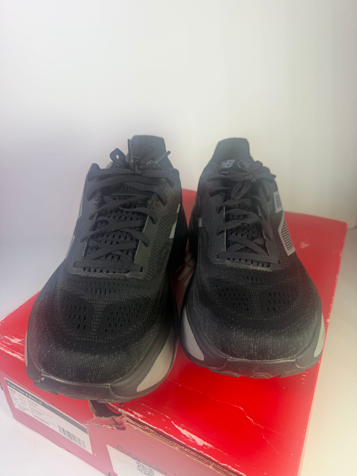 Black New Balance Fresh Foam X More v5 men's athletic running shoes with supportive design and cushioned soles.