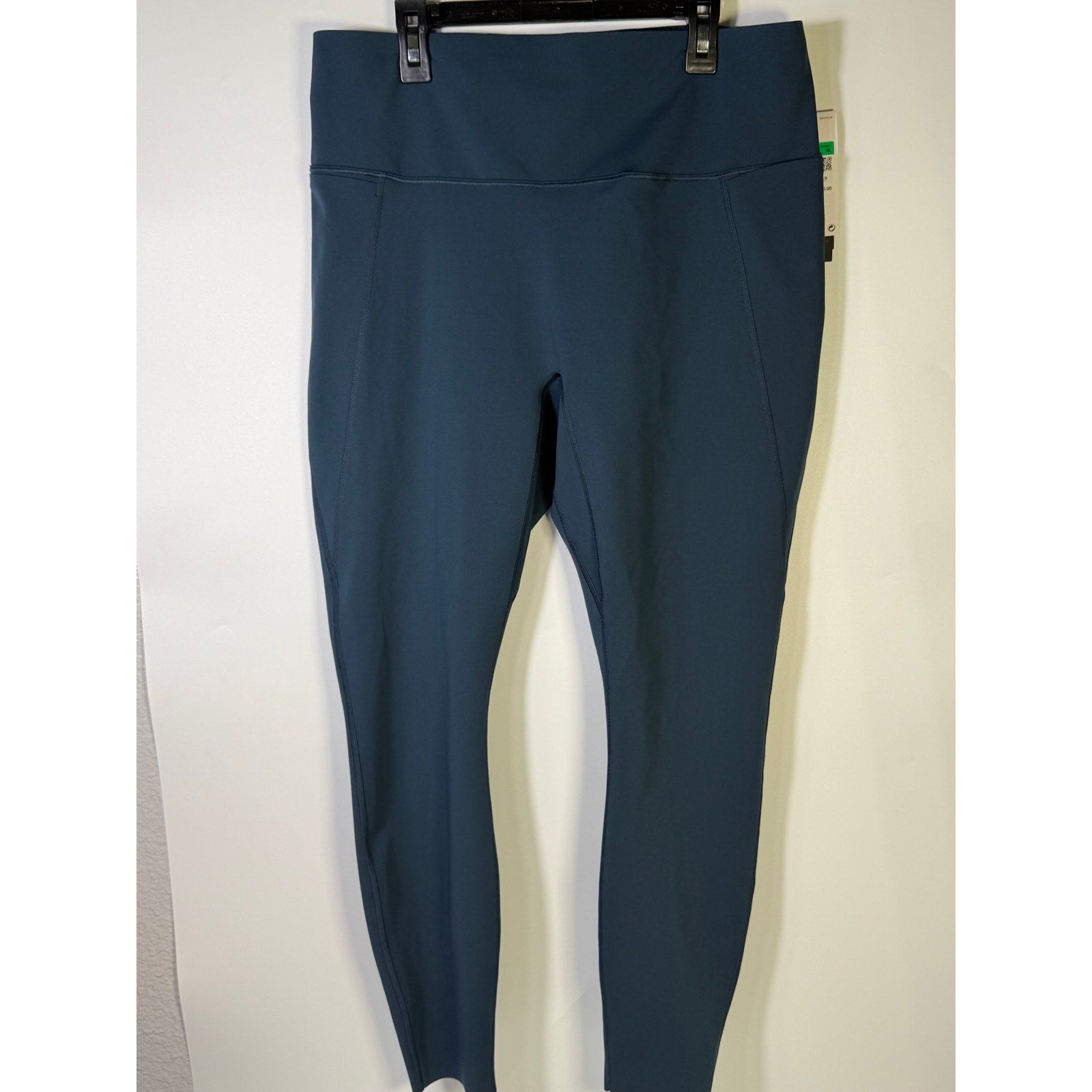 Nike women's blue high-waisted training leggings, XL size, shown laid flat with stretch fabric and sleek design.