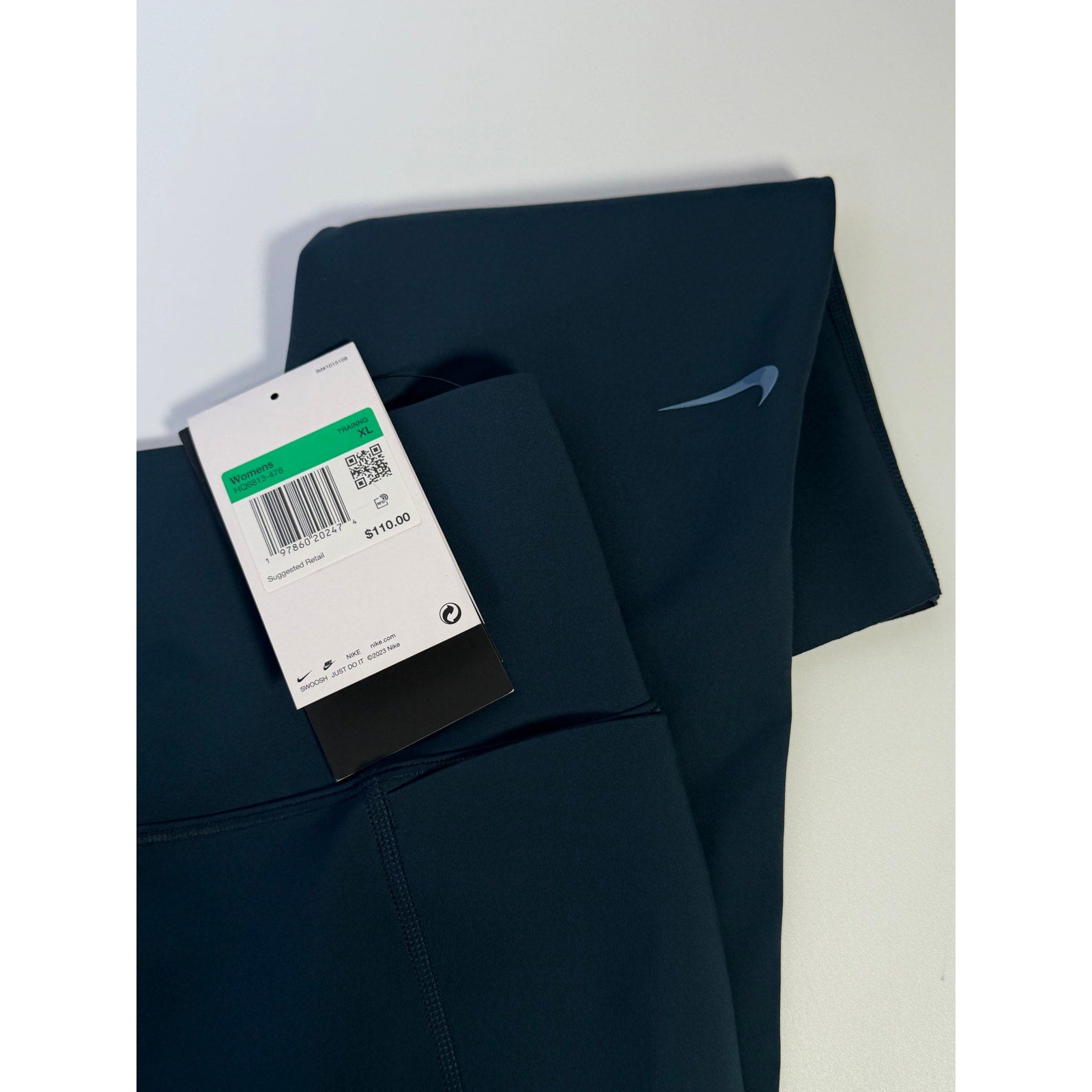 Nike women's blue high-waisted training leggings, XL size, shown on a model with a close-up view of the fabric and fit.