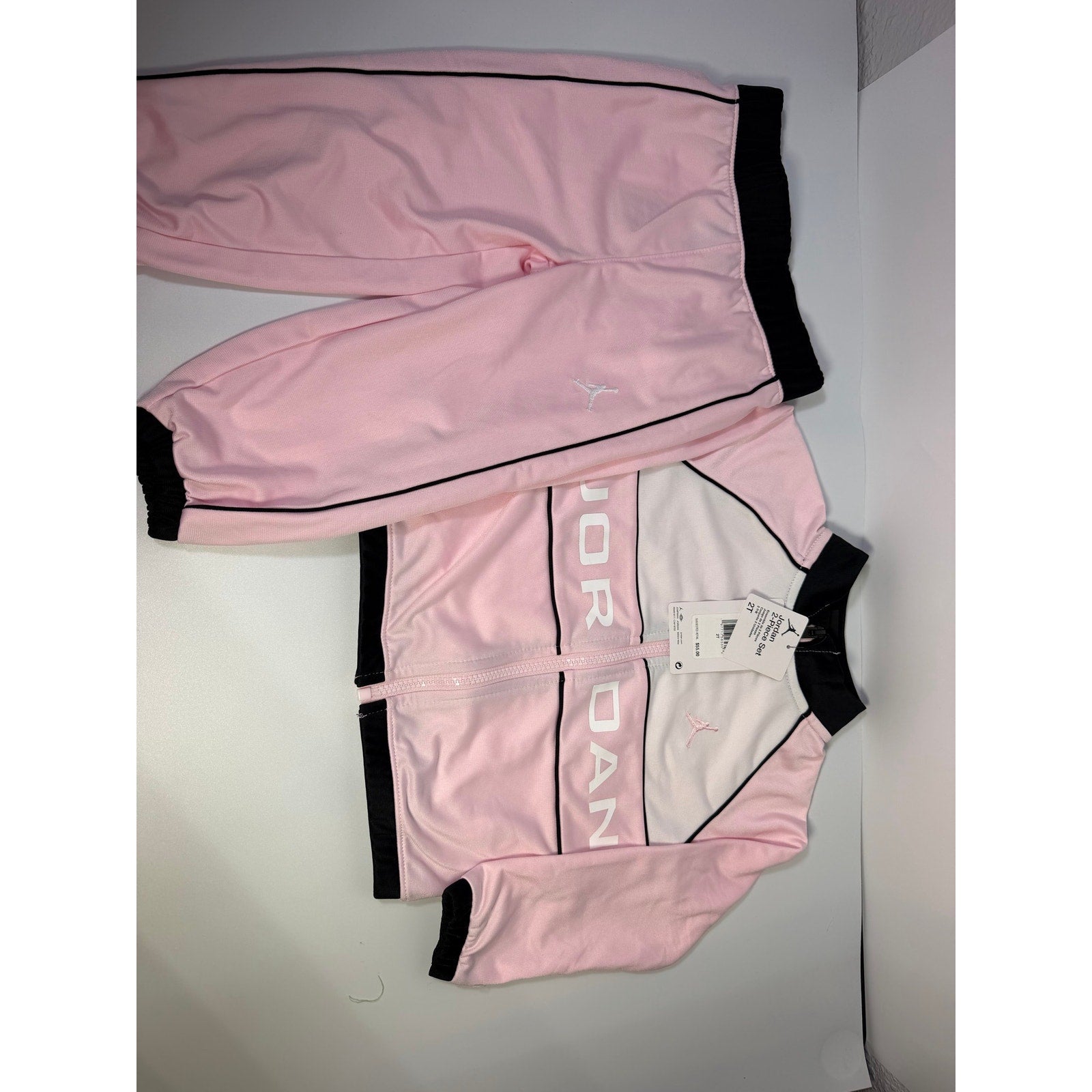 Jordan toddler girls pink and black 2-piece track jacket and pants set, size 2T, showing the jacket and pants laid flat.
