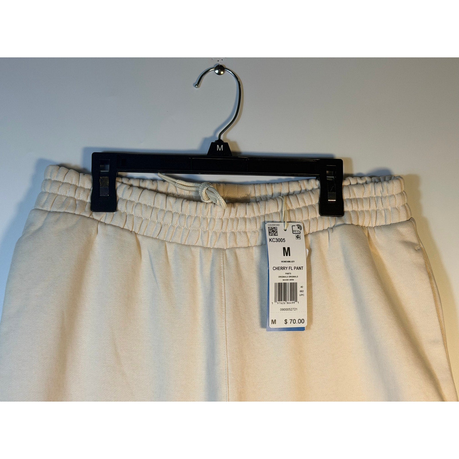 Adidas Originals Cherry FL women's white wide leg sweatpants with relaxed fit and elastic waistband on a hanger.