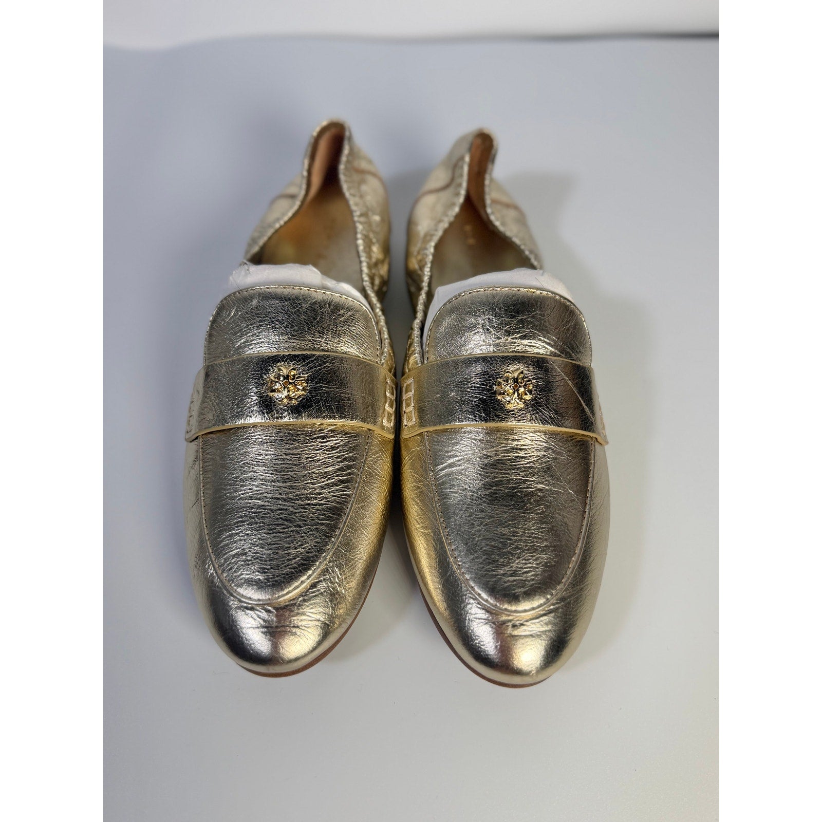 Tory Burch women's gold metallic leather loafers, slip-on flats, size 5M, with sleek design and rounded toe.