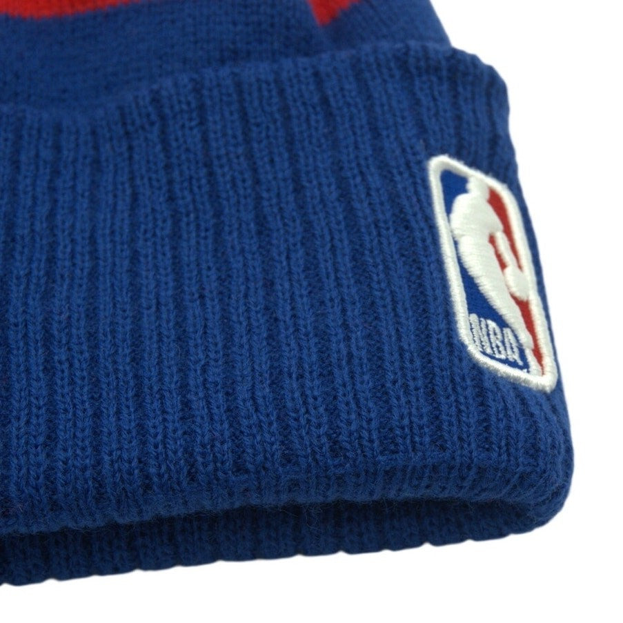 Youth blue and red New Era NBA Sacramento Kings pom beanie hat with knit design, featuring team logo and vibrant colors.