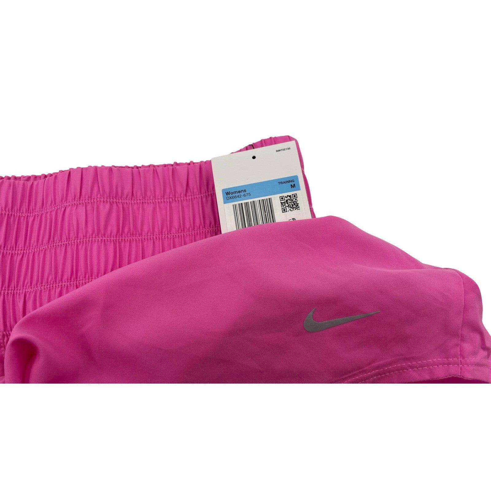 Nike women's pink high-waisted training shorts with Dri-FIT fabric, shown flat with elastic waistband and athletic fit.