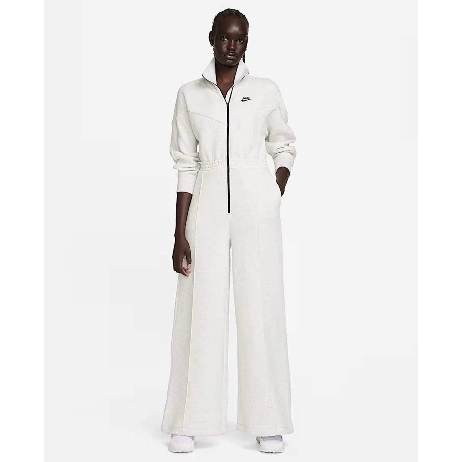 Nike Tech Fleece Windrunner jumpsuit in grey, featuring a hood and sporty design, shown on a model with full-length sleeves and pants.