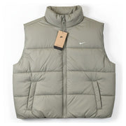 Nike Therma-FIT women's puffer vest in light army green, XL size, featuring a quilted design and stand collar for warmth.