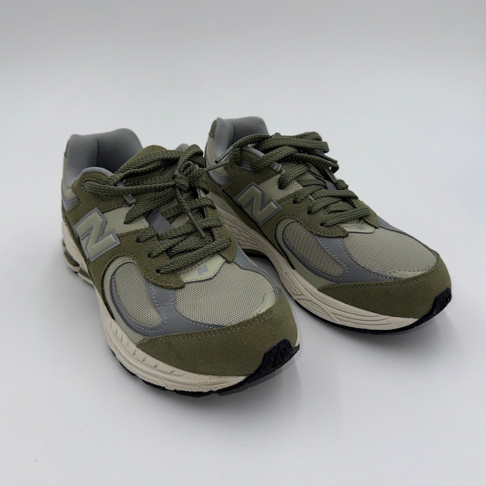 New Balance men's 2002 GS sneakers in excellent condition, showing side view with gray and blue color design.