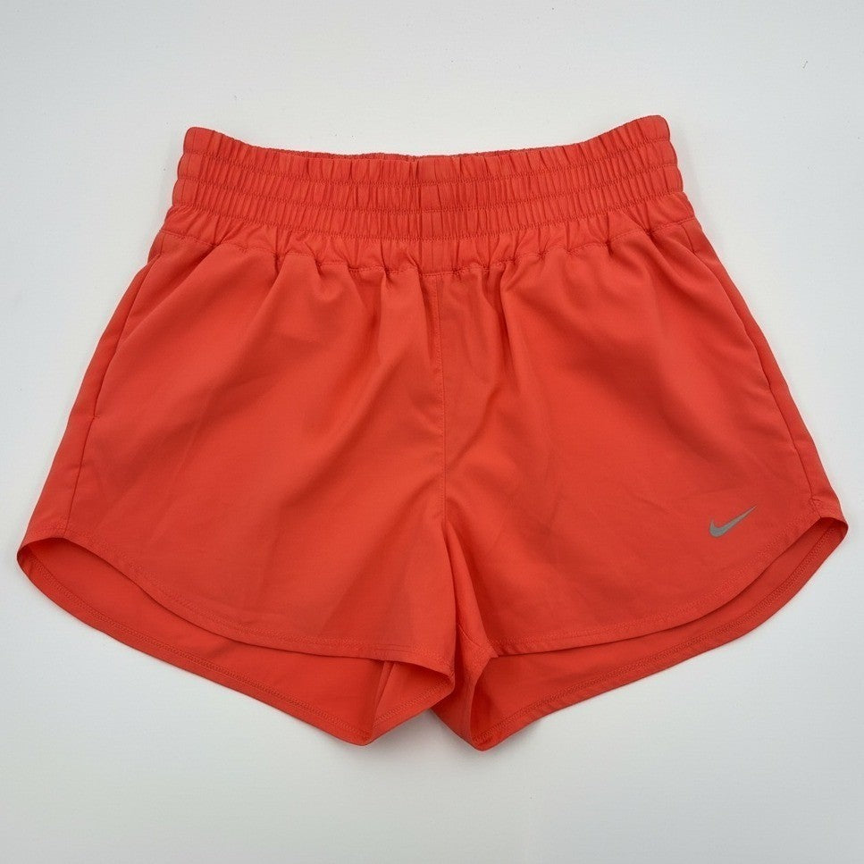 Nike women's coral training shorts, high-waisted Dri-FIT athletic shorts in size XL, shown on a model with a sporty background.