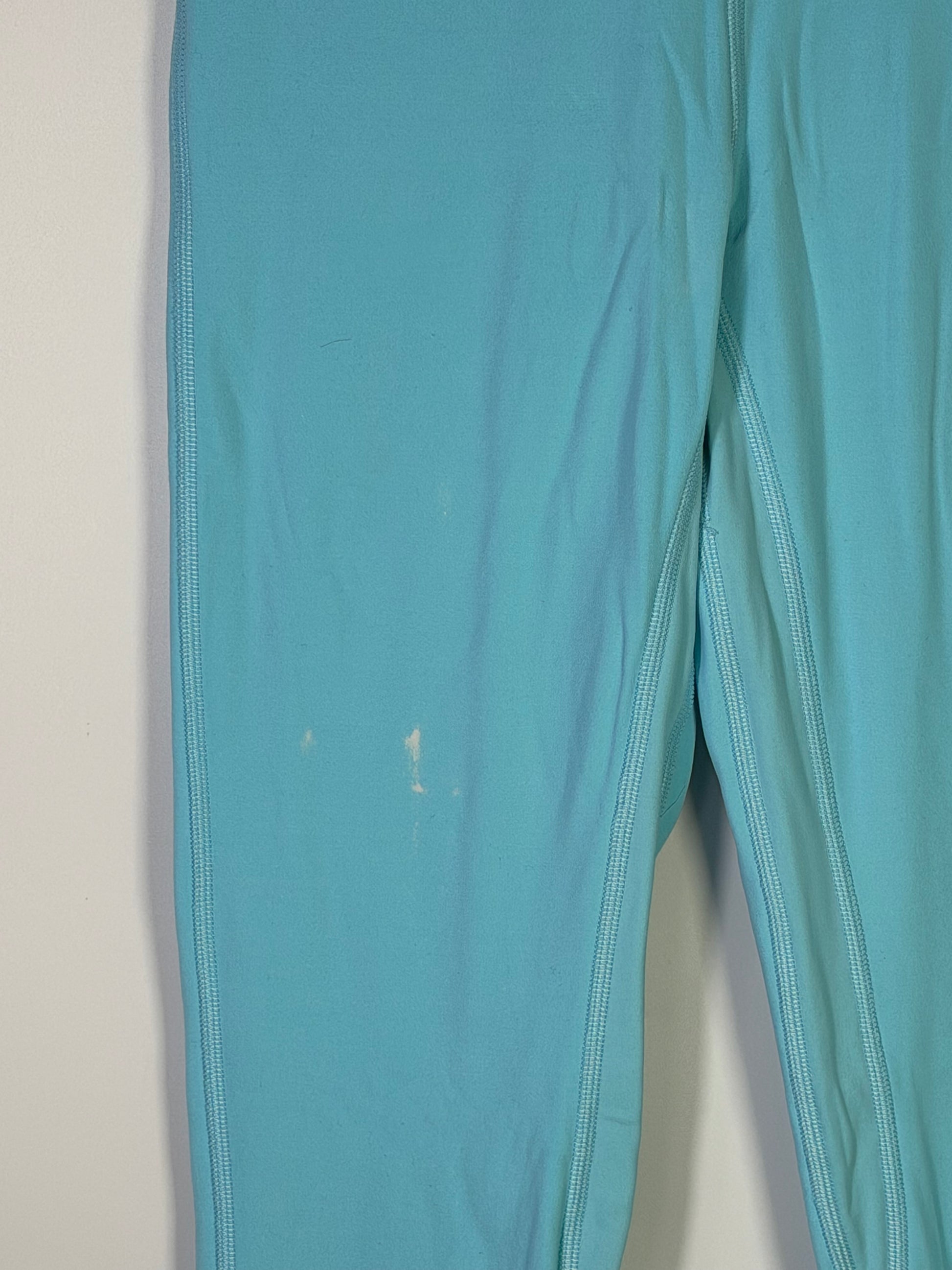 Lululemon women's size 4 aqua blue high-rise full-length leggings displayed on a model, highlighting the fitted athletic clothing.