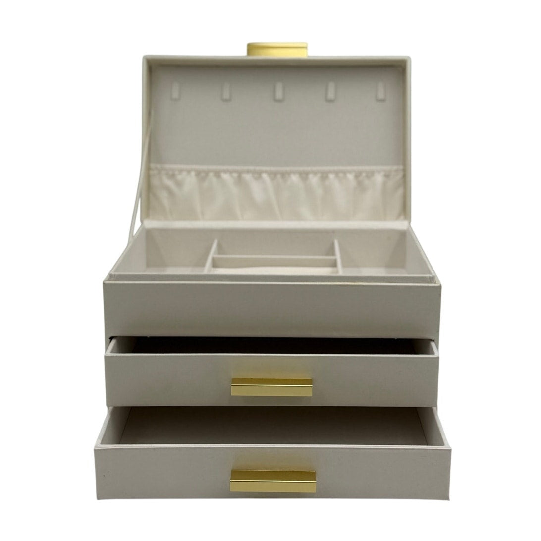 Ivory 3-tier faux leather jewelry box with champagne gold handles and faux suede lining, designed for elegant jewelry storage.
