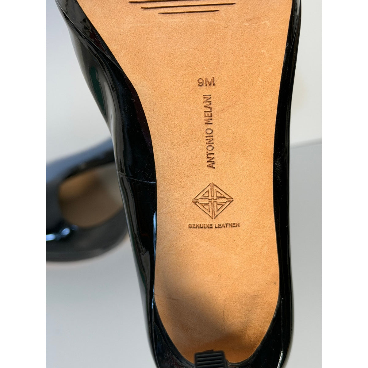 Black patent leather Antonio Melani women's high heel pumps in size 9M, featuring a classic pointed toe and sleek design.