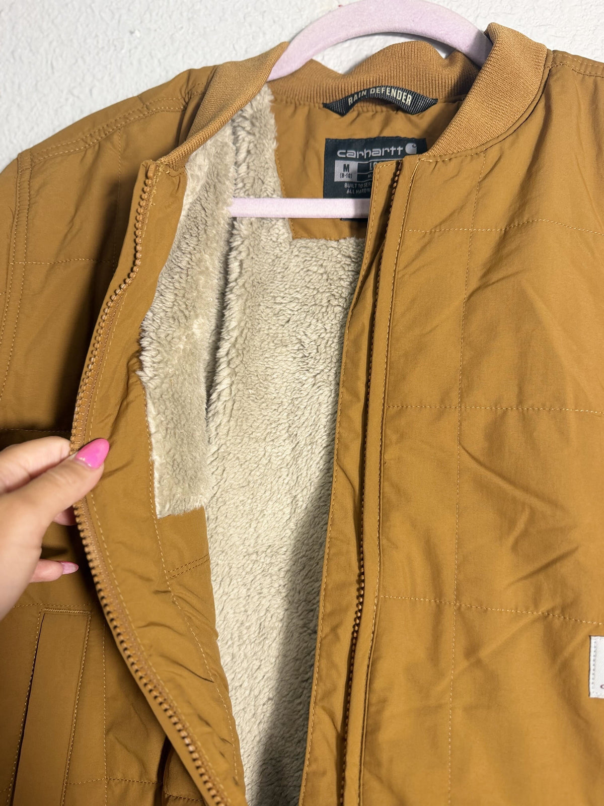 Carhartt Rain Defender loose fit quilted Sherpa-lined jacket in brown for women, medium size, with visible quilting and Sherpa lining.