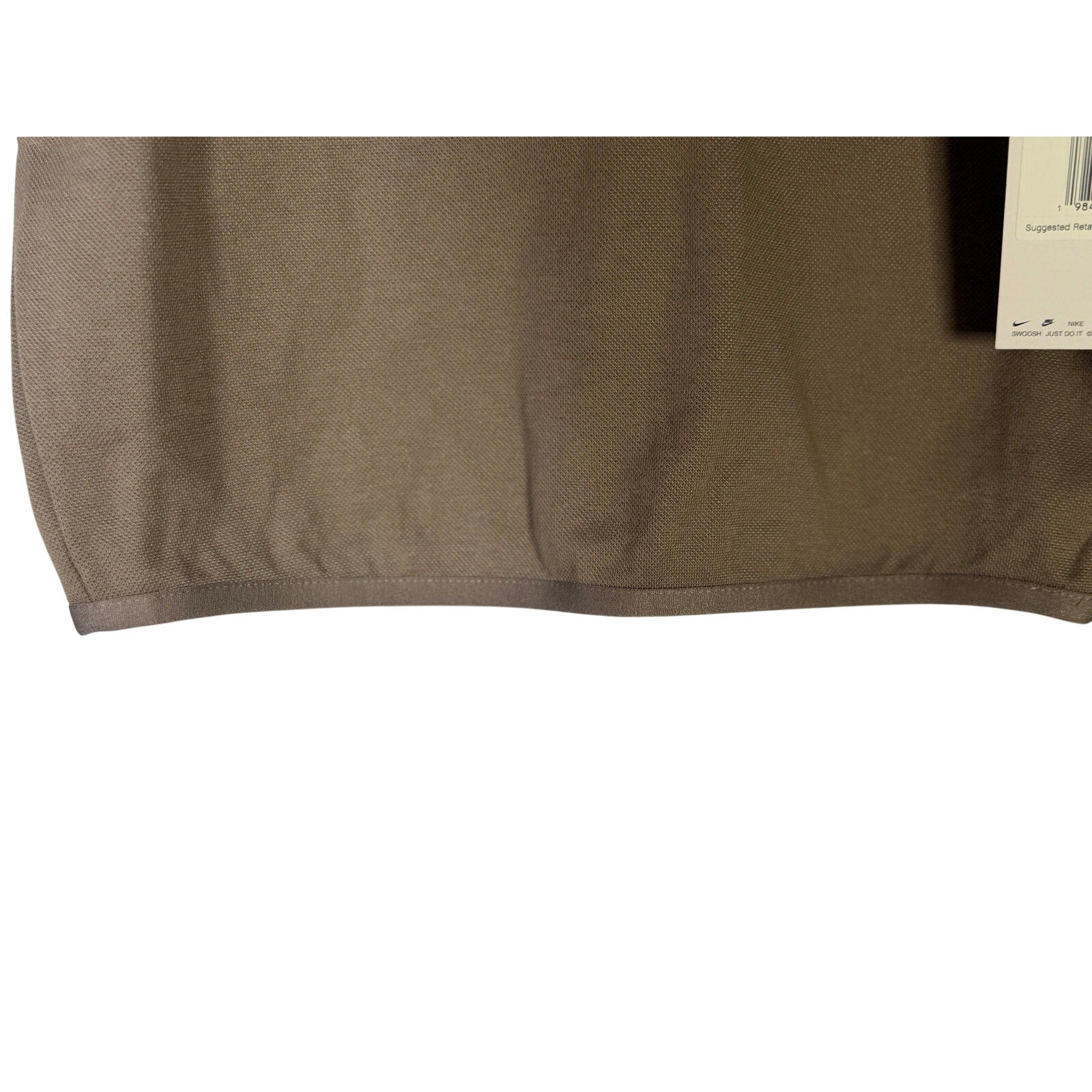 Nike women's short-sleeve golf polo in mink brown, size XS, displayed on a hanger.