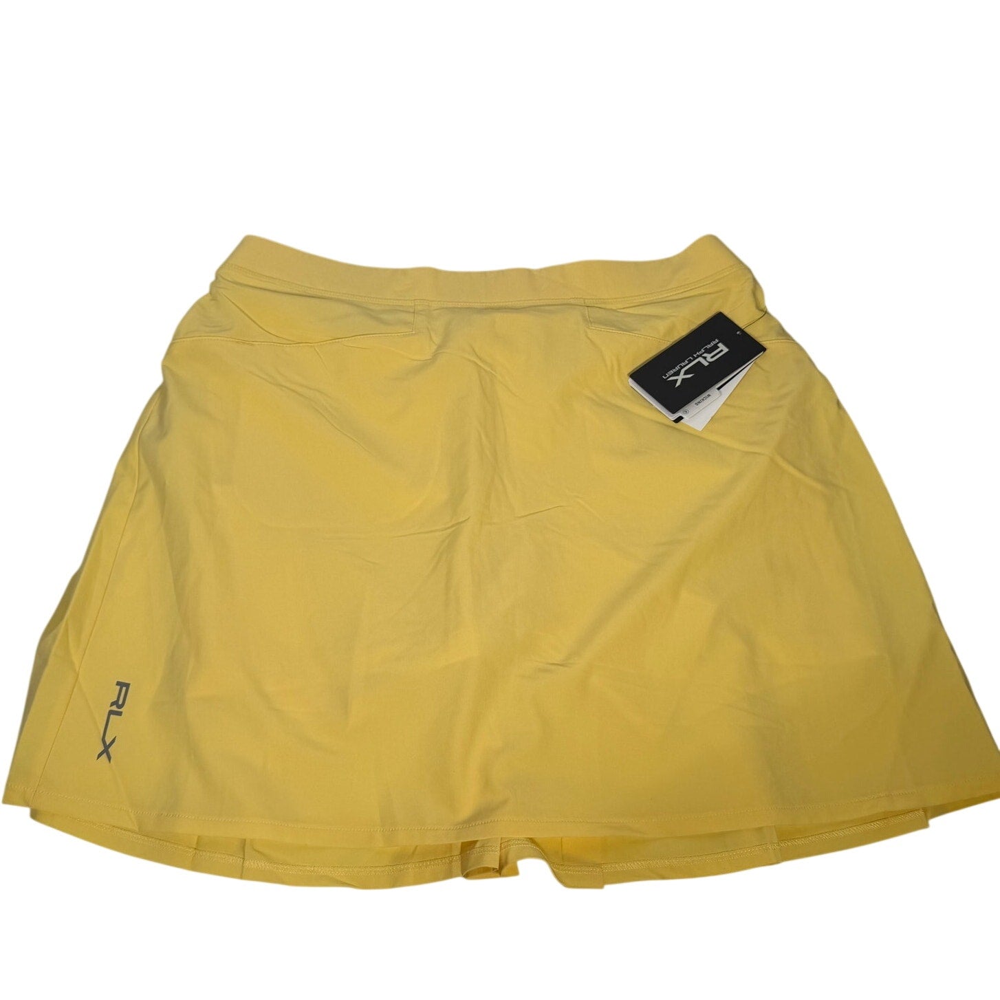 Ralph Lauren RLX women's yellow pleated golf skort, size M, with tags, shown laid flat highlighting the pleats and fabric texture.