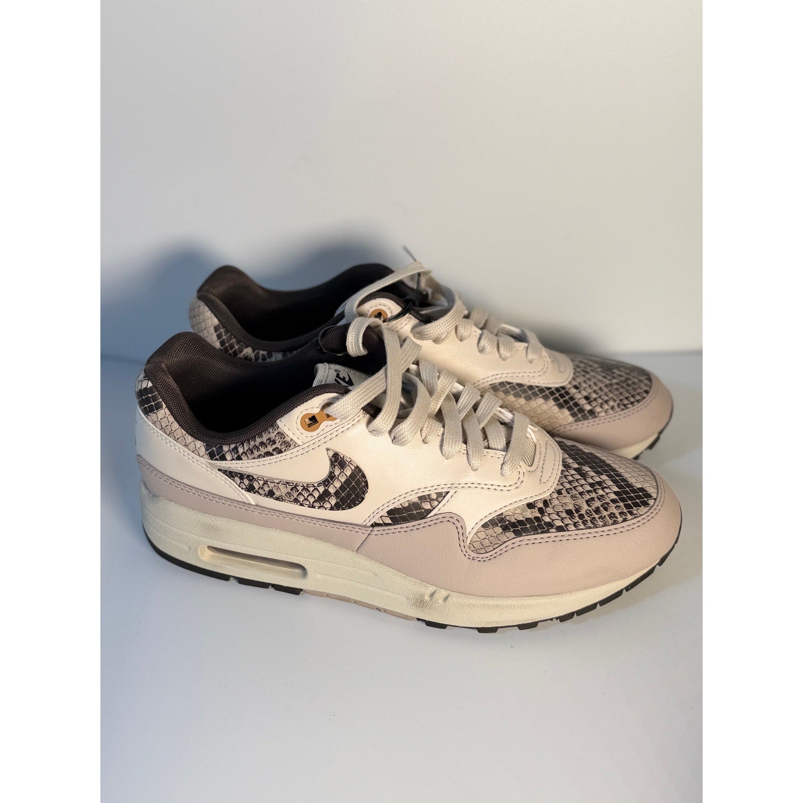 Nike Air Max 1 Premium Snakeskin sneakers in white and gray, women's size US 9.5, featuring textured snakeskin design.
