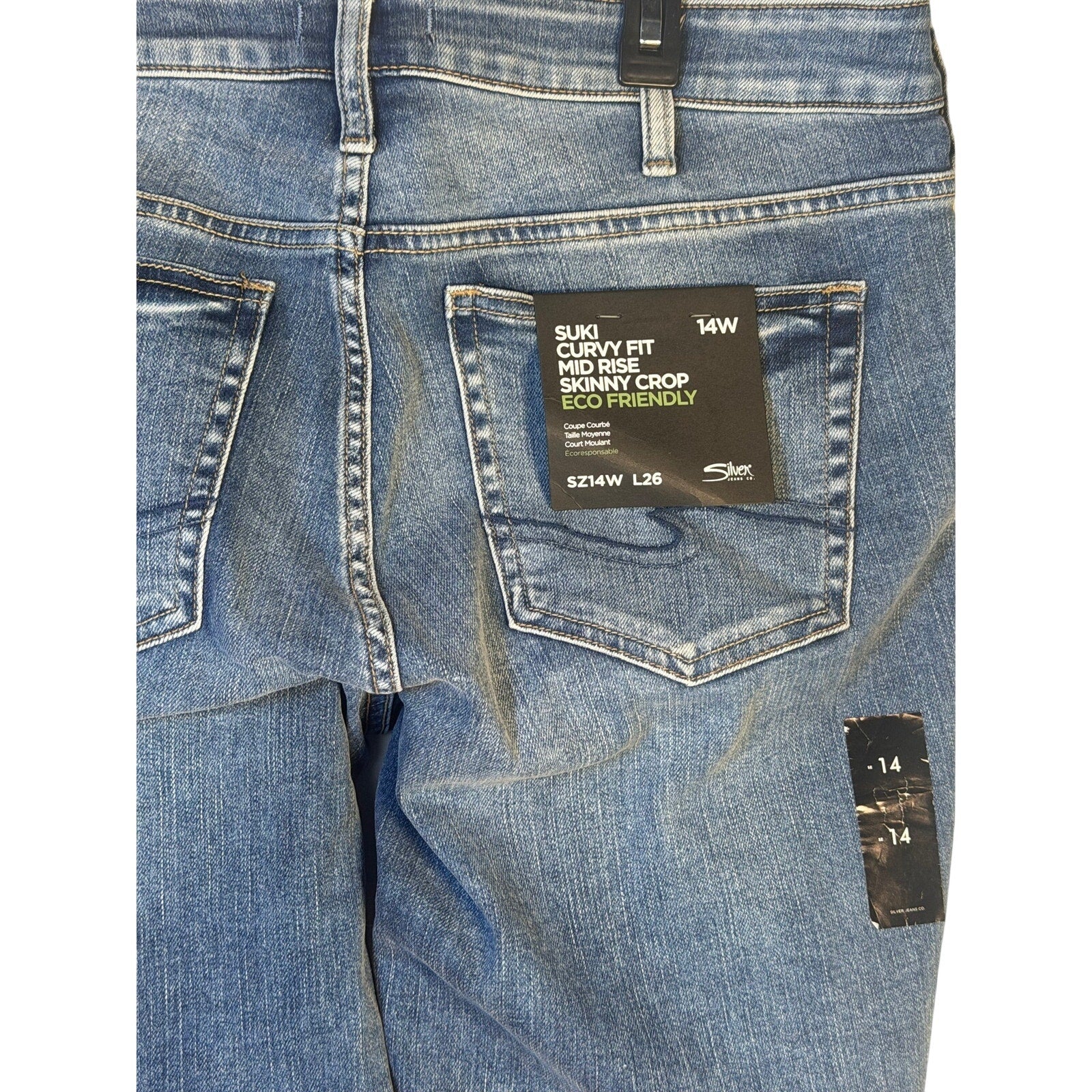 Silver Jeans Co. Suki curvy fit mid-rise skinny crop jeans in size 14W, shown on a model with a casual pose.