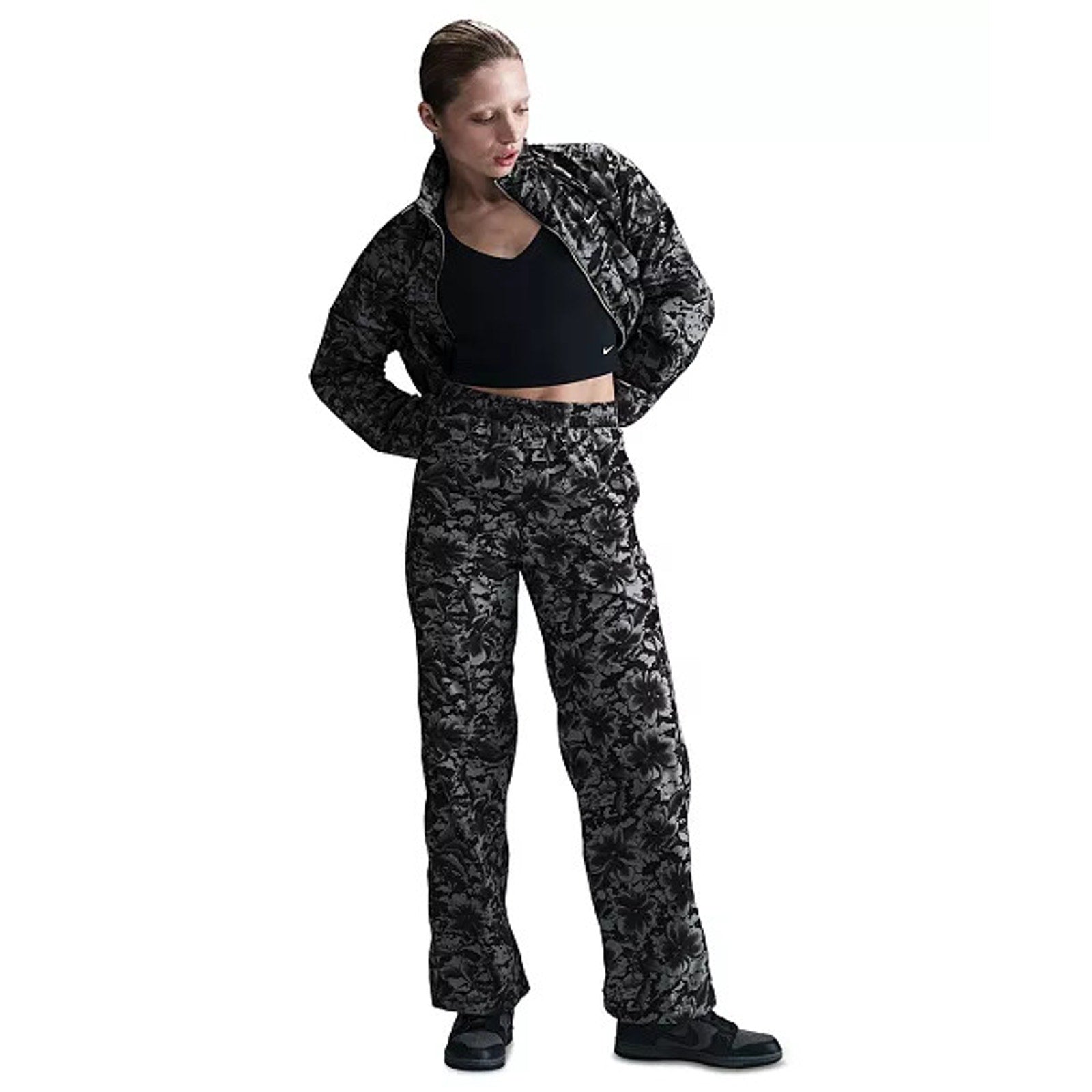 Nike Sportswear women's floral wide-leg track pants in black and gray with high-rise fit, relaxed style, and floral pattern.