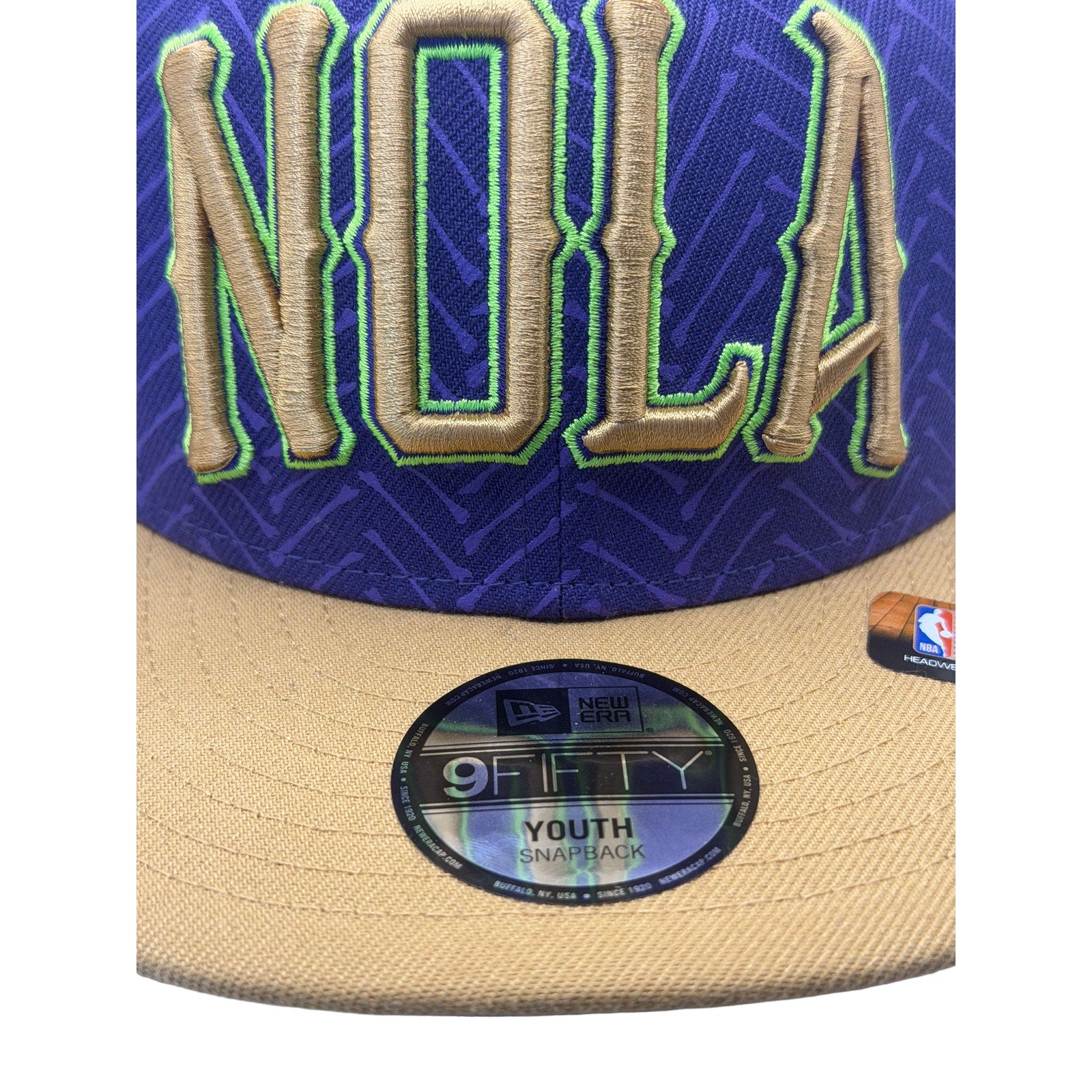 New Era NOLA Pelicans 9FIFTY youth snapback hat in purple and gold with NBA logo, featuring team branding and adjustable fit.