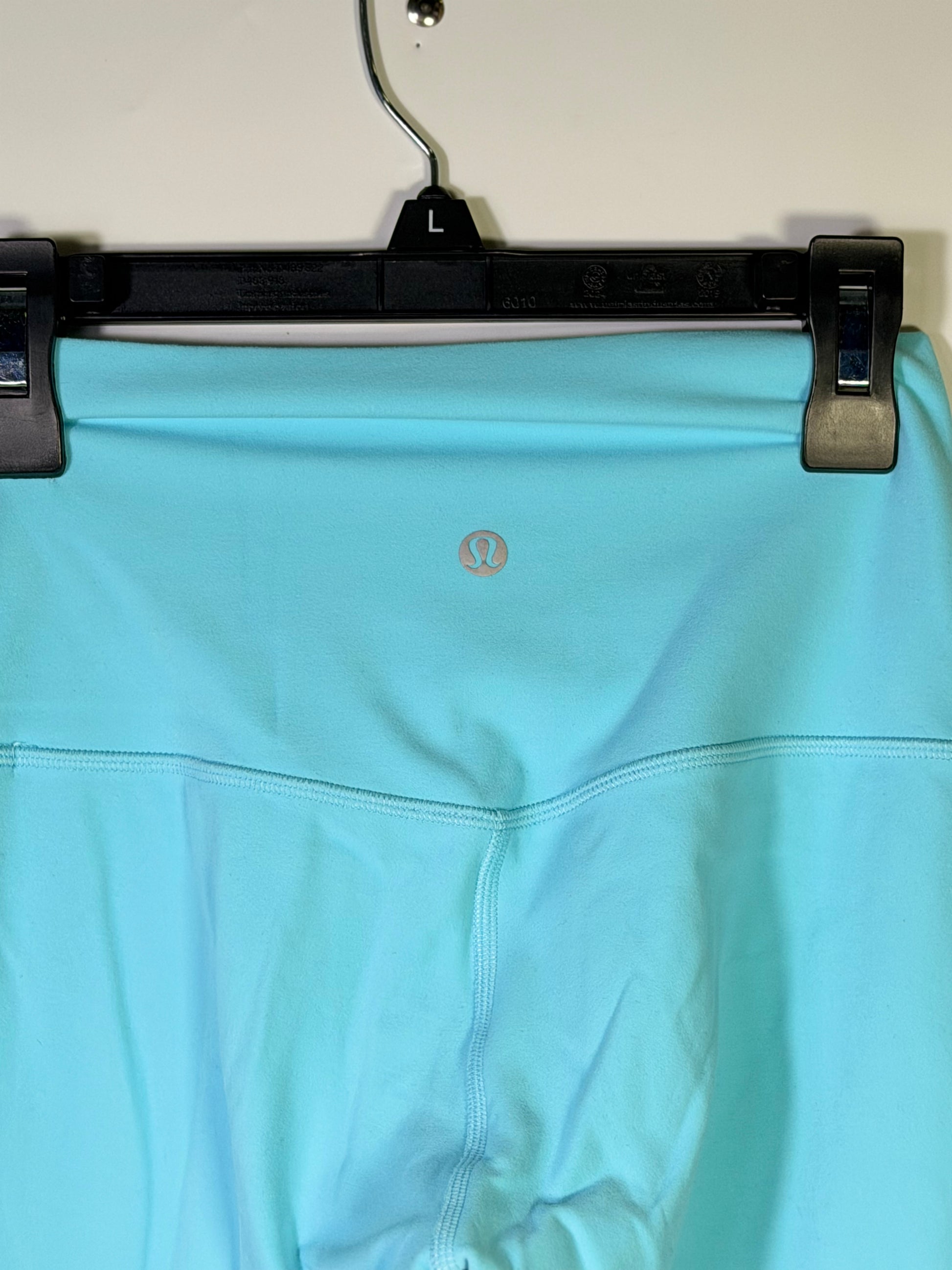 Lululemon women's size 4 aqua blue high-rise full-length leggings laid flat, showcasing the smooth, stretchy fabric and waistband.