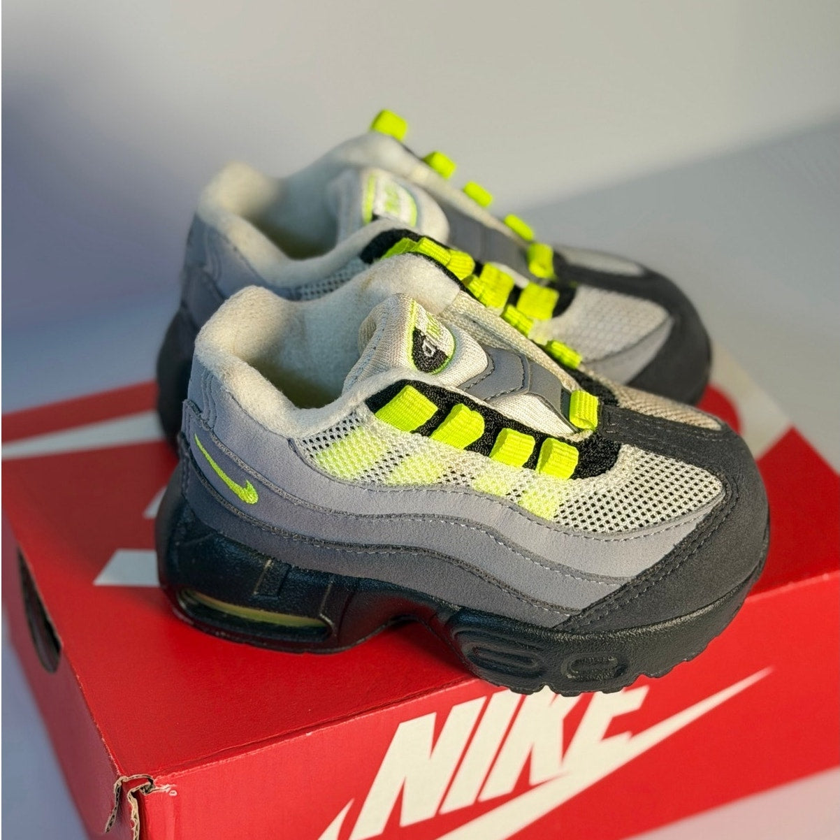 Nike Air Max 95 toddler sneakers in gray, volt, and black with running shoe design for kids.