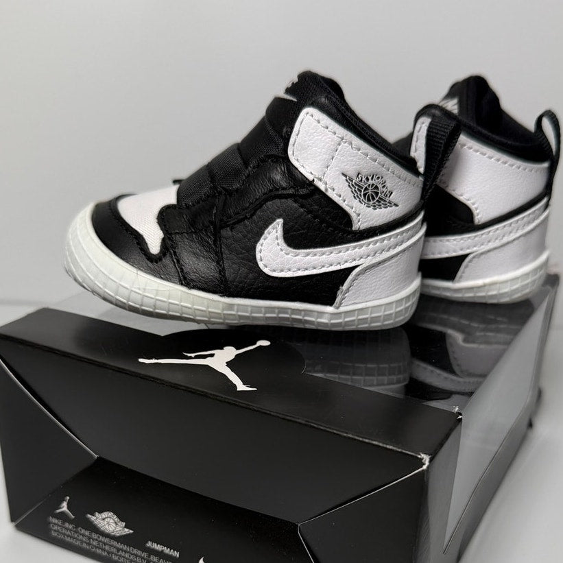 Black and white Nike Air Jordan 1 Retro High OG infant crib shoes in size 2C, featuring classic sneaker design for babies.