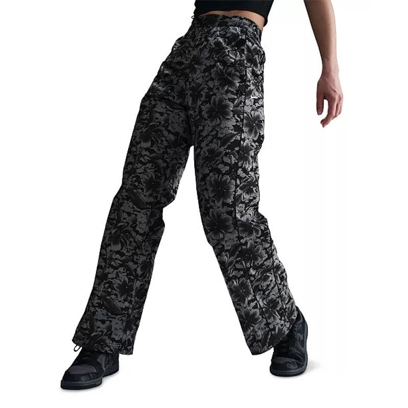 Nike Sportswear women's floral wide-leg track pants in black and gray, featuring a relaxed fit and floral pattern.
