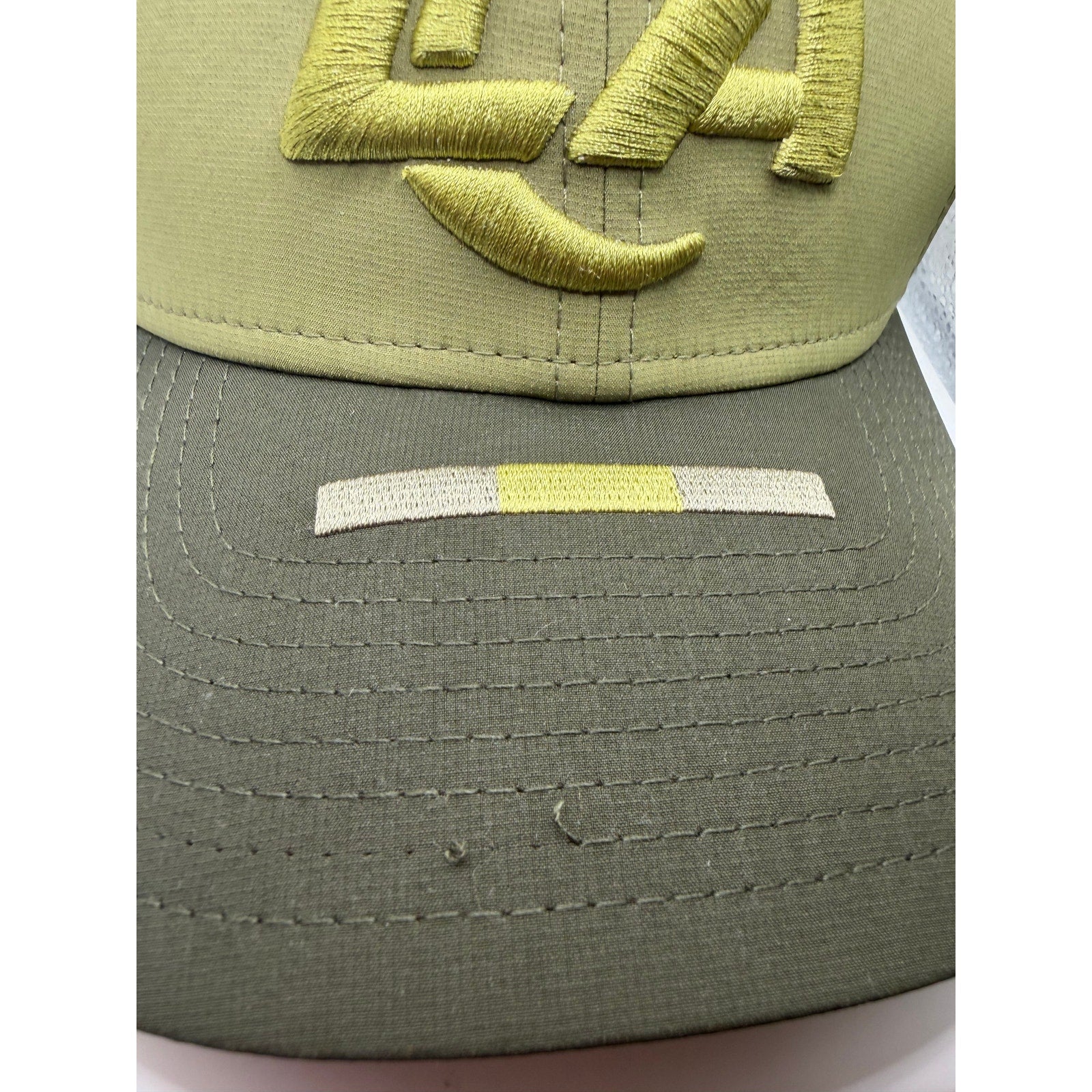 Olive green Los Angeles Rams NFL New Era 39THIRTY Salute to Service hat with team logo and embroidered details.