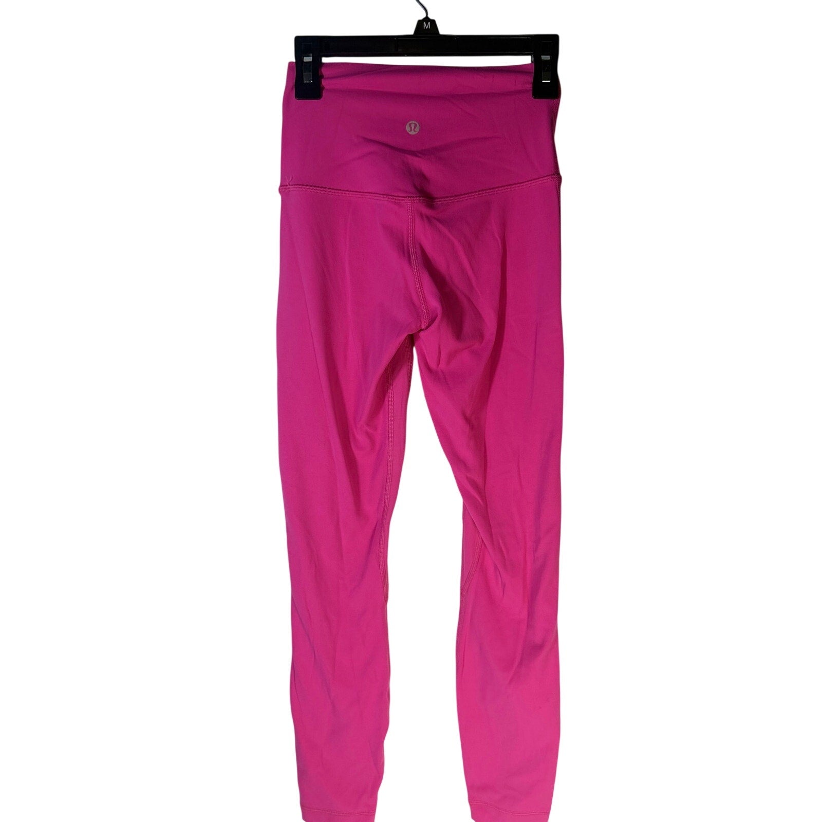 Pink Lululemon Wunder Under high rise leggings for women, size 2, athletic pants with a close-up of the stretchy fabric and high waistband.