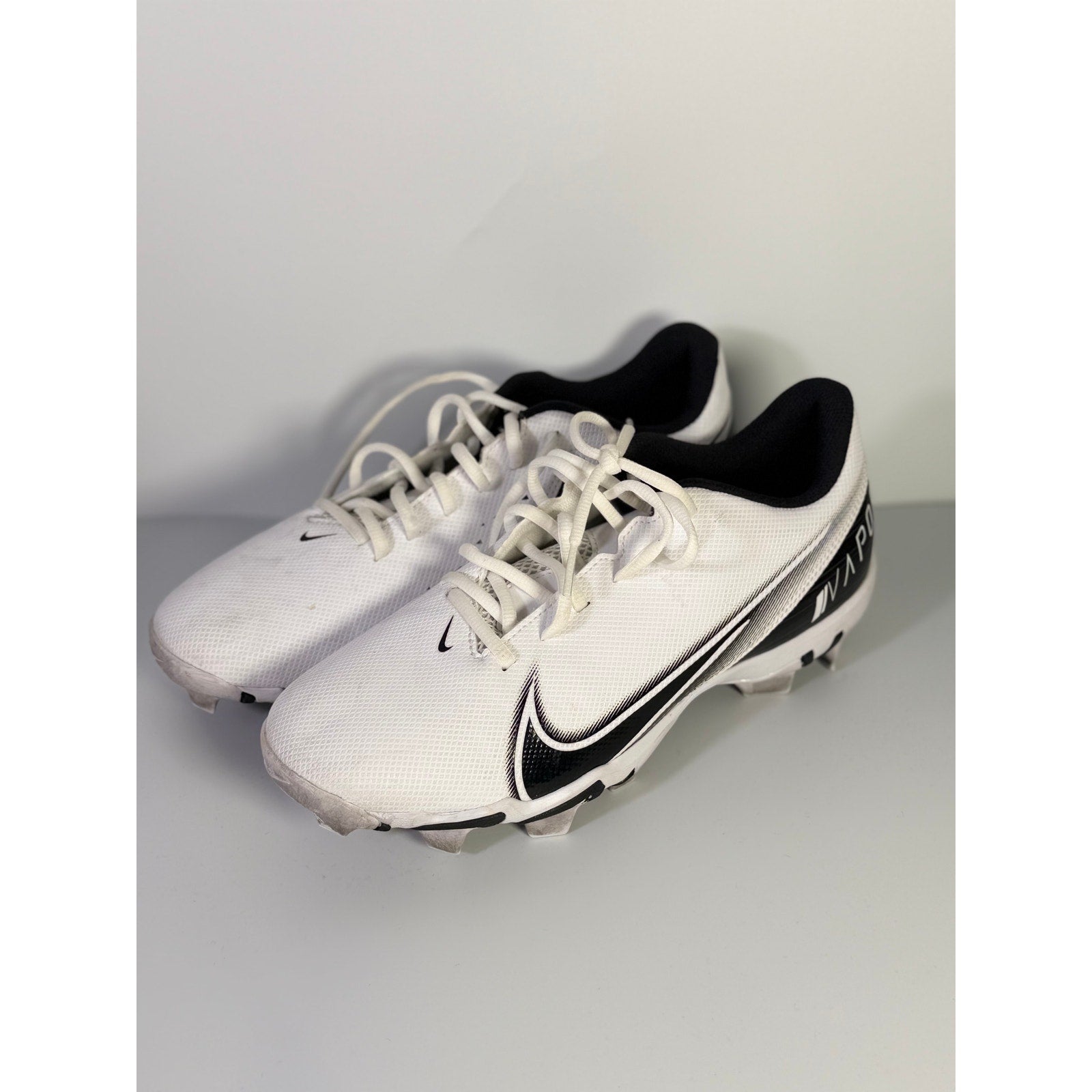 Nike Vapor football cleats in white and black for men, size 8.5 US, featuring a sleek design and durable cleat studs.