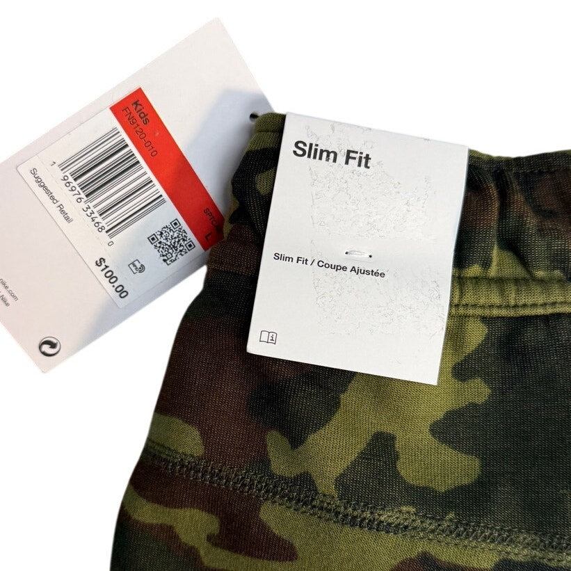 Youth large Nike Sportswear Tech Camo jogger pants with slim fit design, featuring camouflage pattern and athletic style.