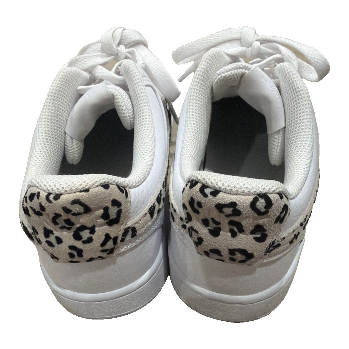 Nike Court Vision Low Leopard Swoosh white sneakers for women, showing white leather shoes with leopard print accents and Nike swoosh logo.