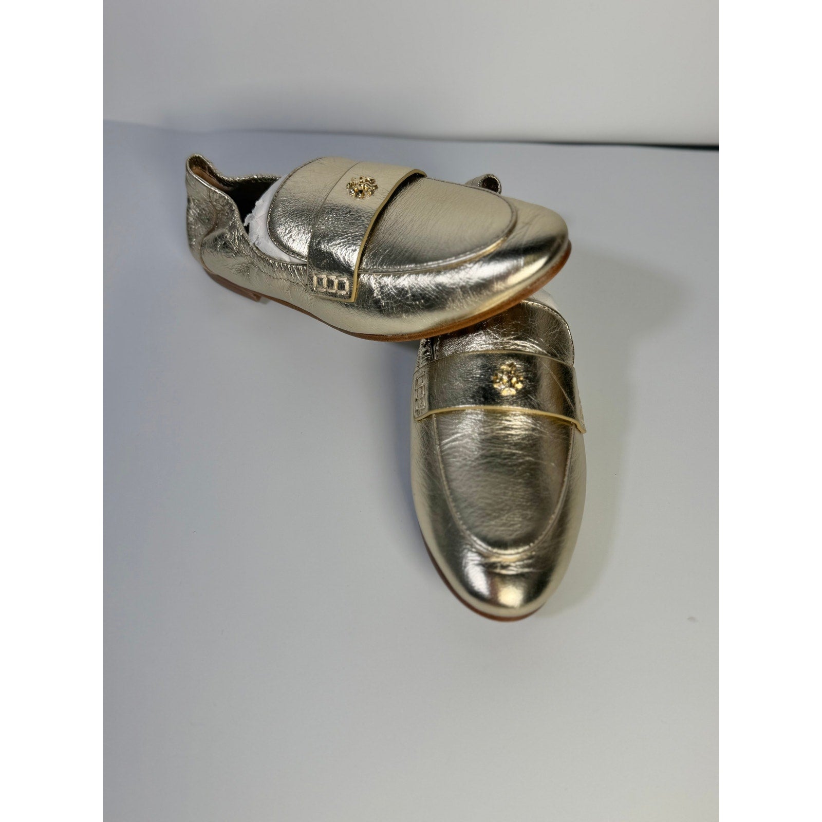 Tory Burch women's gold metallic leather slip-on loafers, size 5M, with a sleek and shiny finish, stylish flat footwear.