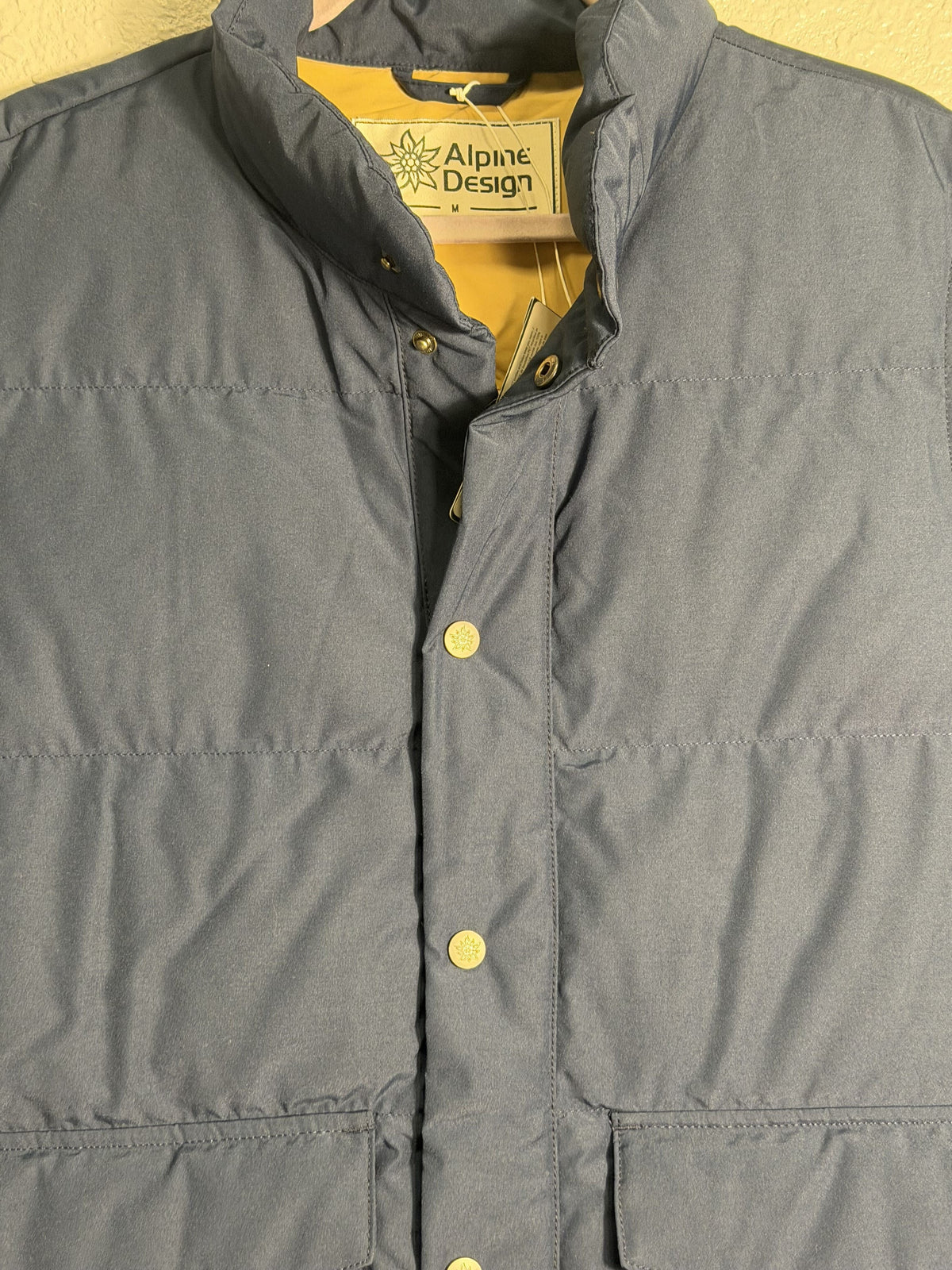Men's Alpine Design AD 1962 Puffer Vest in vintage blue, size medium, showing the quilted puffer design and front zipper.