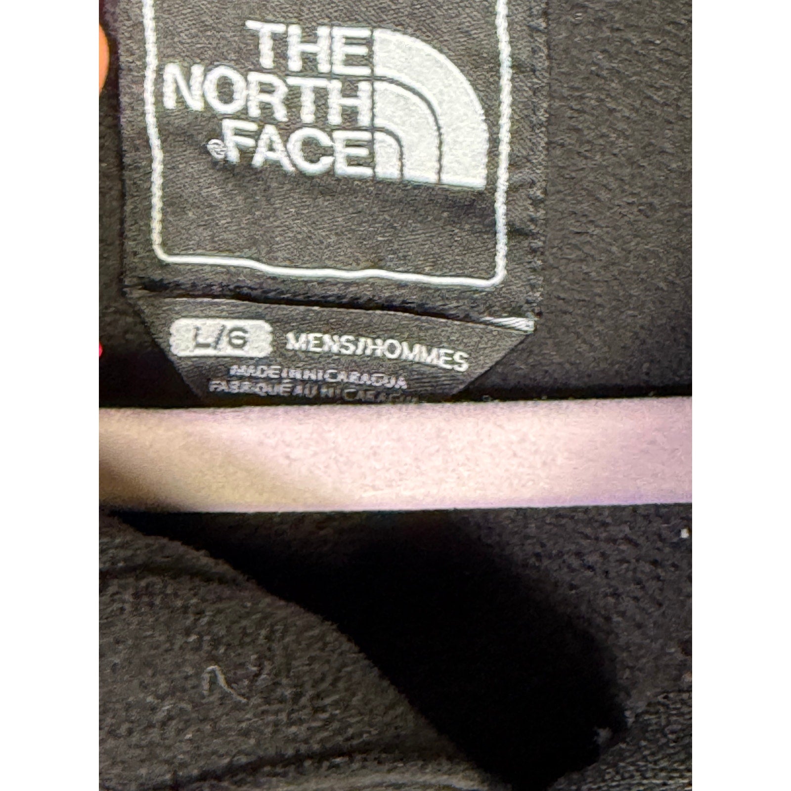 The North Face men's black softshell jacket with full zip and fleece lining, shown on a hanger or worn, ideal for cold weather.
