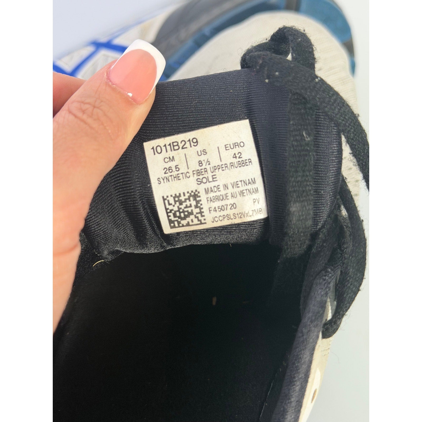 Men's ASICS Gel Cumulus 24 running sneakers in white, blue, and black with cushioned athletic design and breathable mesh fabric.