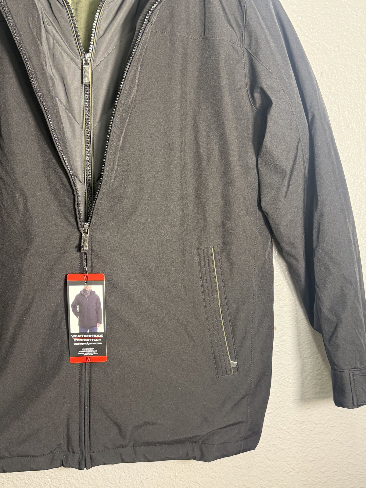 Men's Weatherproof stretch tech hooded jacket with quilted bib in black, showcasing the weatherproof design and modern fit.