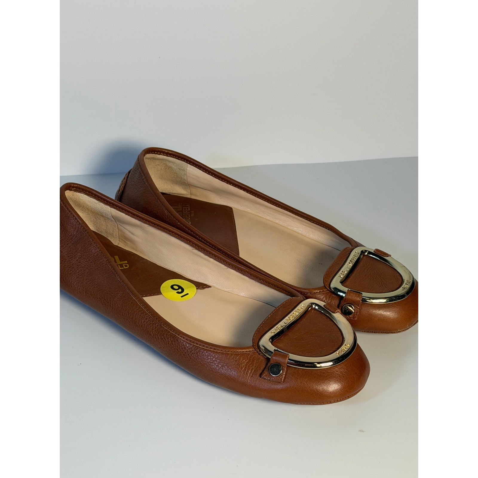 Karl Lagerfeld Paris women's brown ballet flats with gold logo hardware, US size 9, pre-owned, showcasing elegant slip-on design.