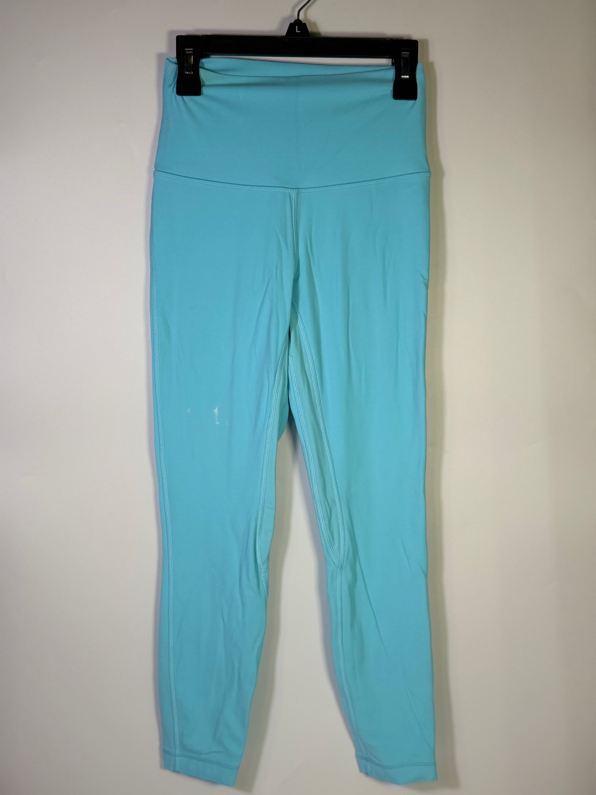 Lululemon women’s size 4 aqua blue high-rise full-length leggings worn on a model, showcasing the fitted athletic clothing.