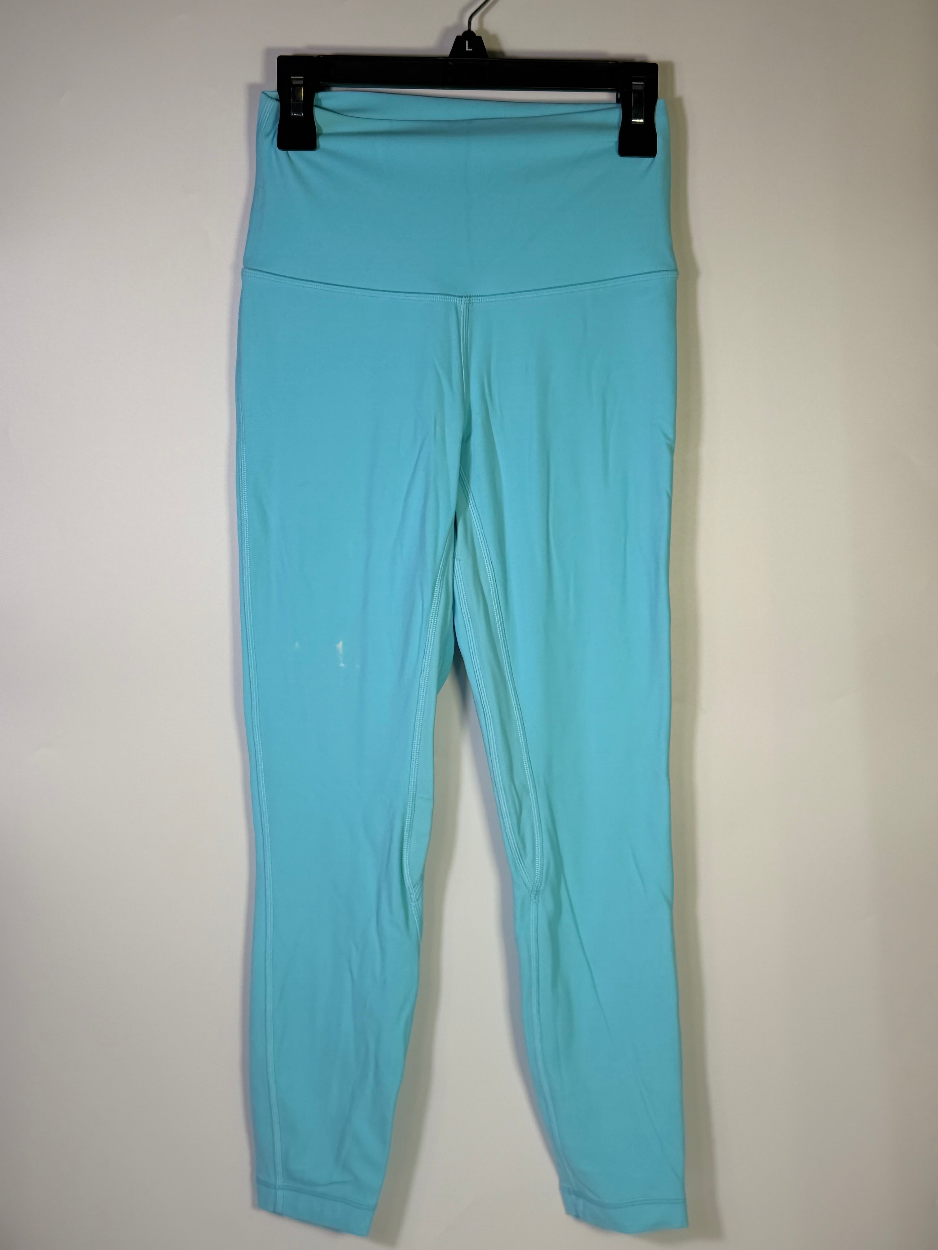 Lululemon women’s size 4 aqua blue high-rise full-length leggings worn on a model, showcasing the fitted athletic clothing.