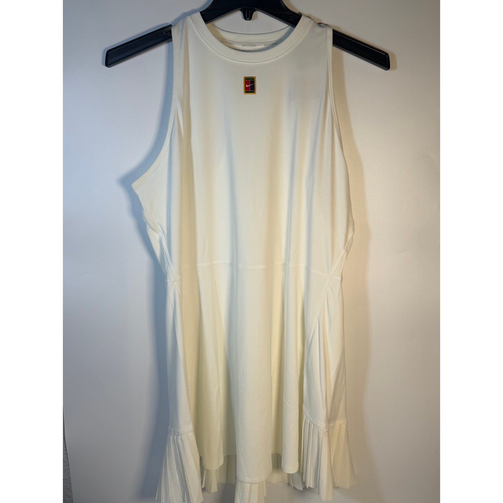 NikeCourt Dri-FIT tennis dress for women in white, sleeveless design, size XL, shown on a hanger.